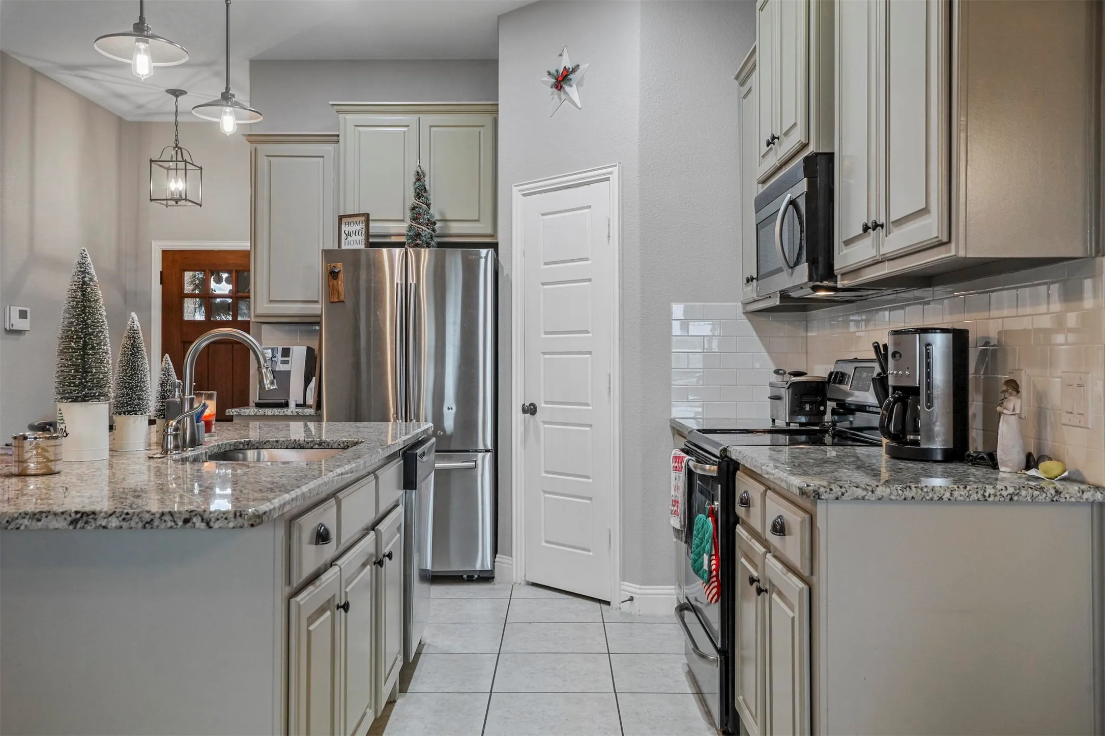 Kitchen with light gray cabinetry and granite countertops