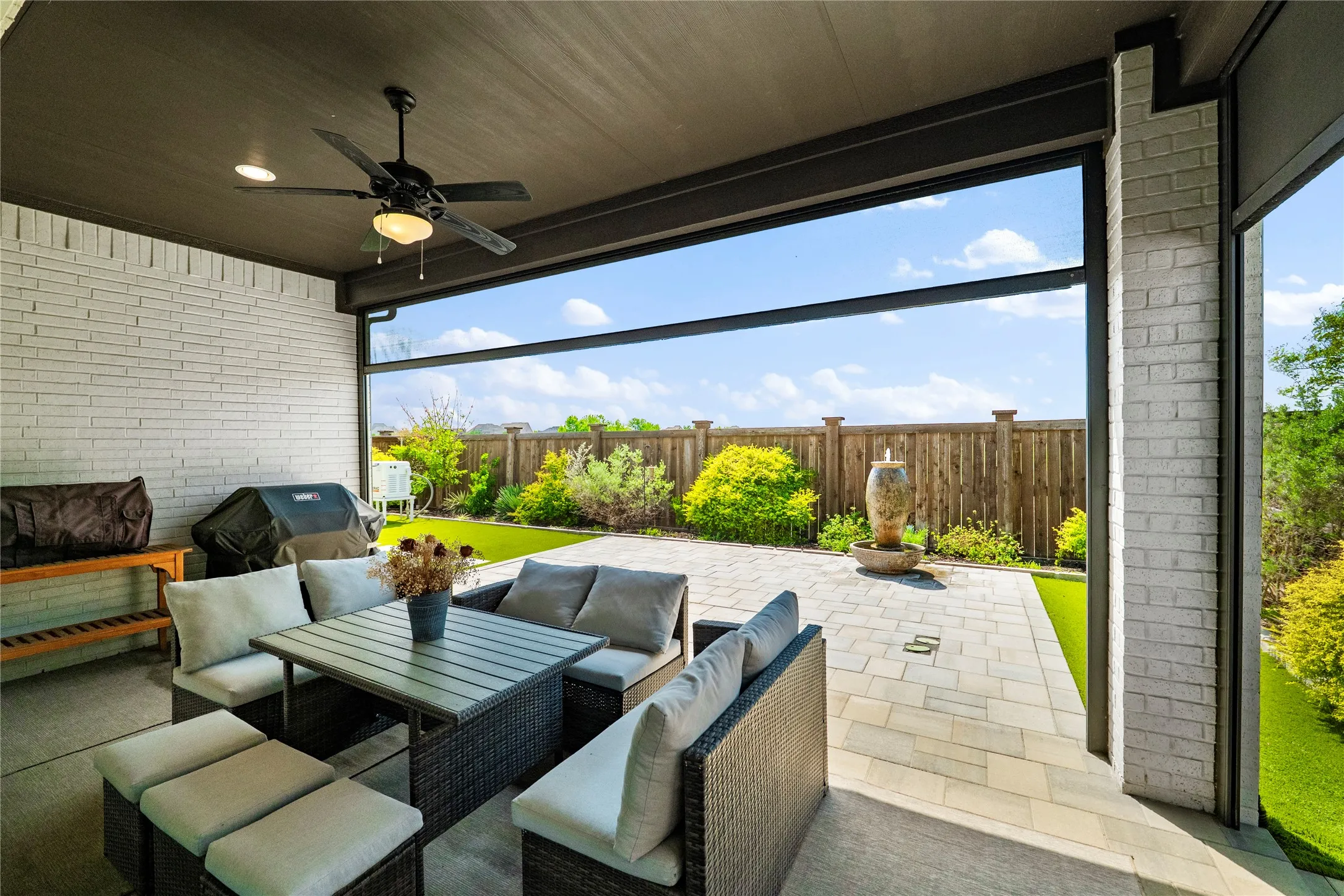 Fenced backyard with a ceiling fan, a patio area, grilling area, and outdoor seating