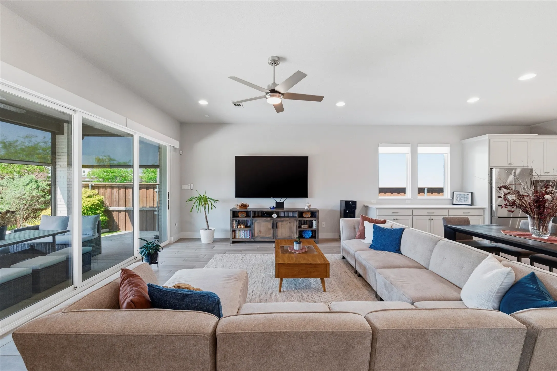 Living area with ceiling fan, healthy amount of natural light, light wood-type flooring, and recessed lighting