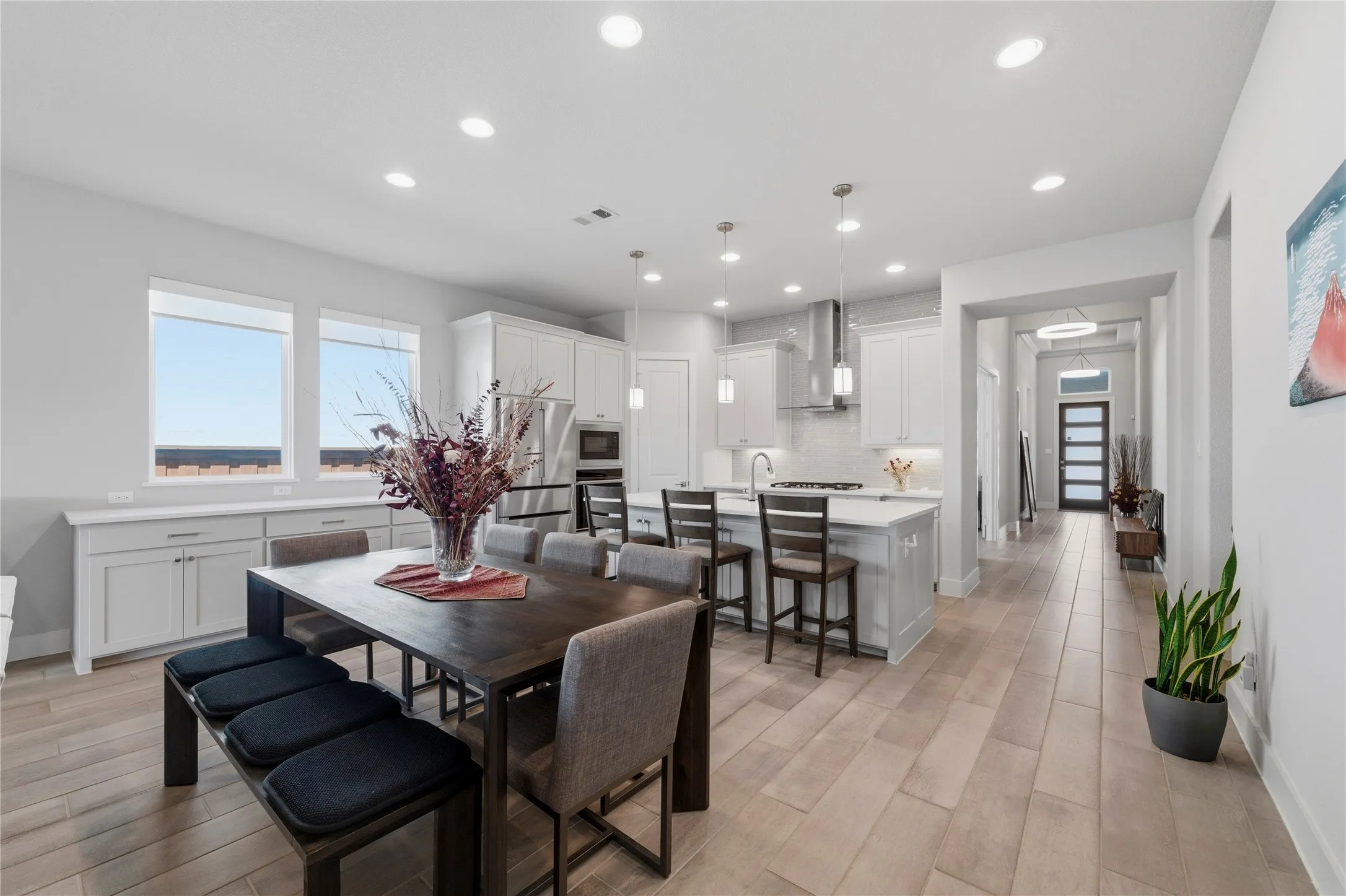 Dining room with light wood-style floors and recessed lighting