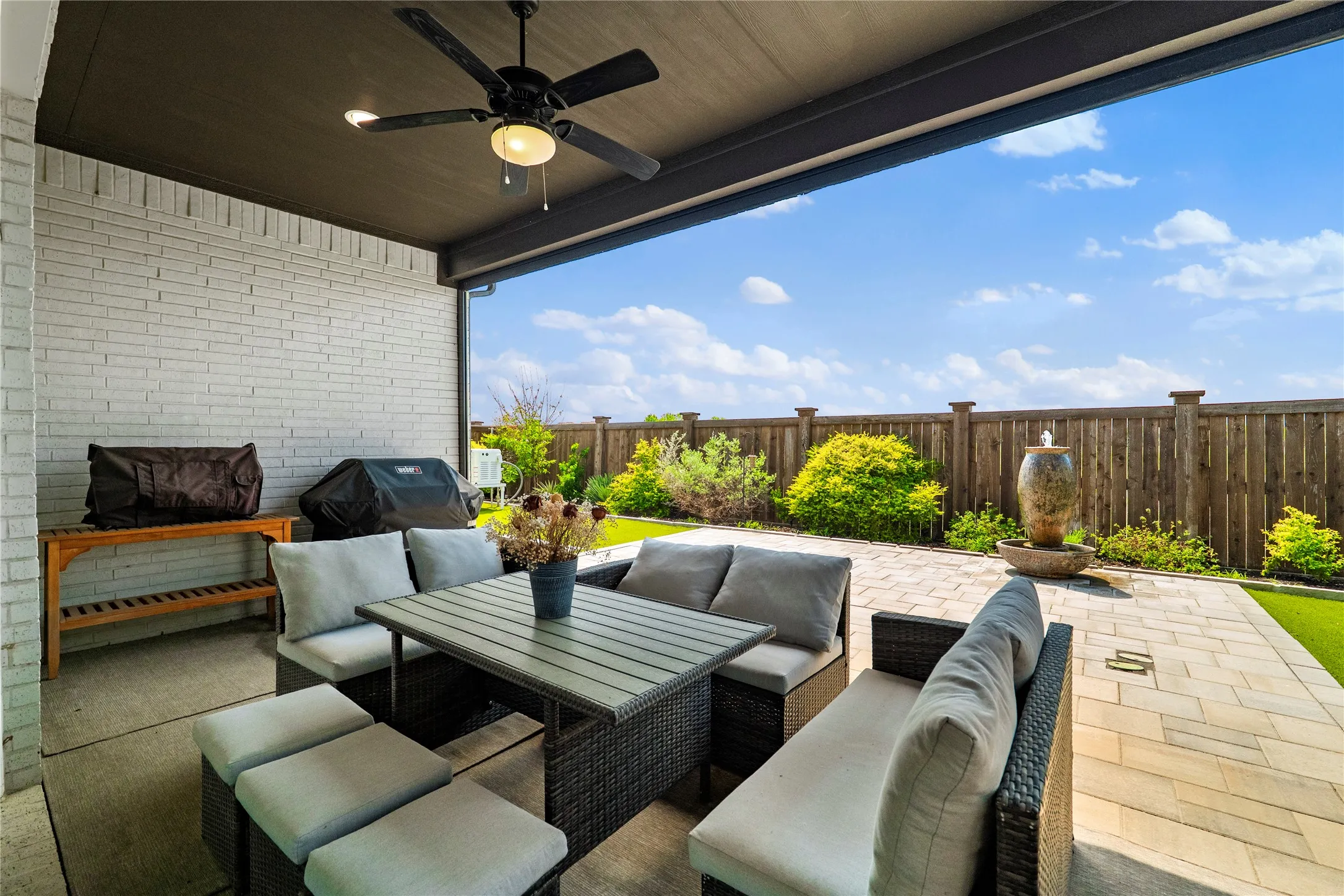 Fenced backyard featuring ceiling fan, a patio area, an outdoor living space, and area for grilling