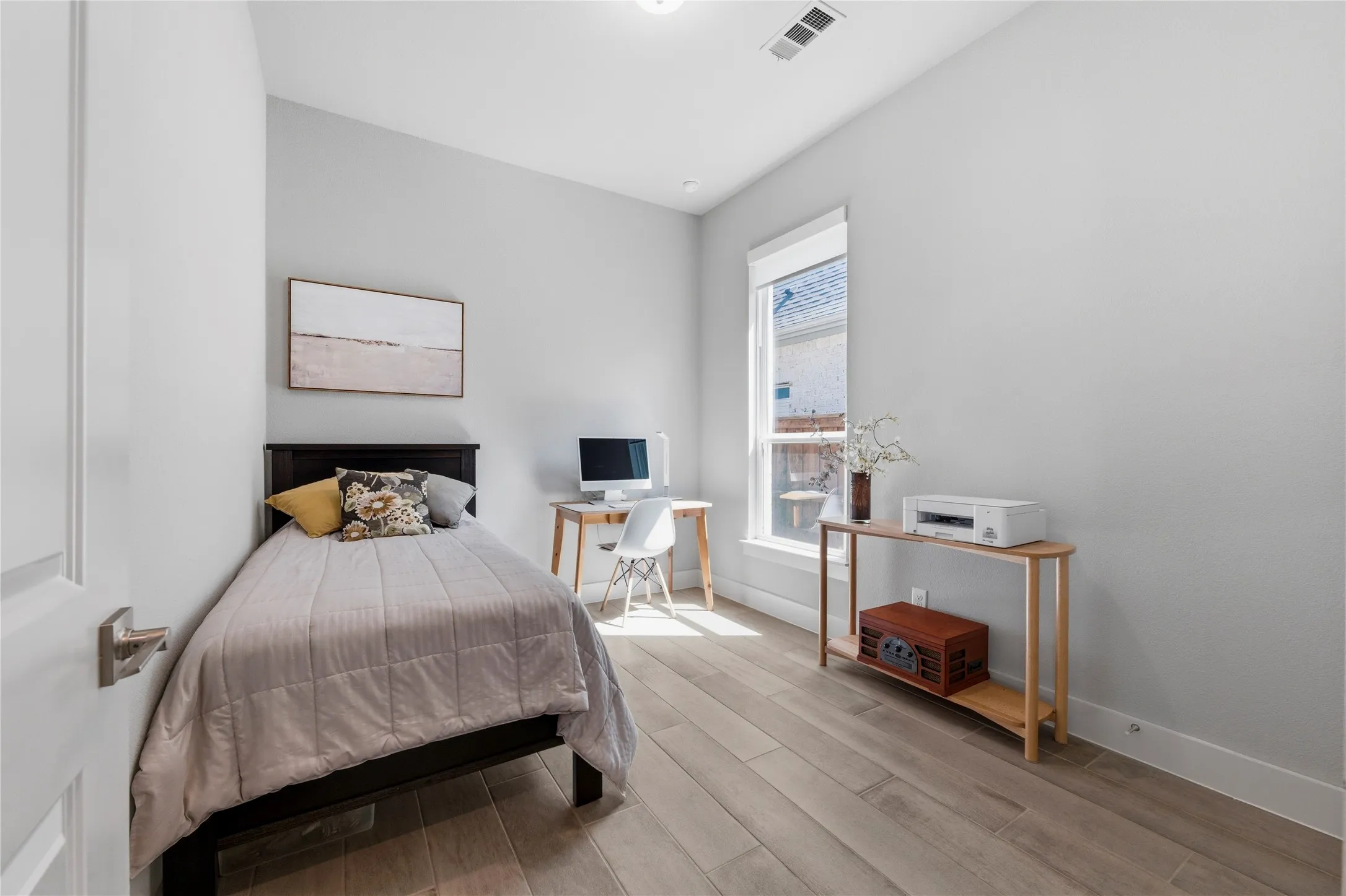 Bedroom with a desk and light wood-style flooring