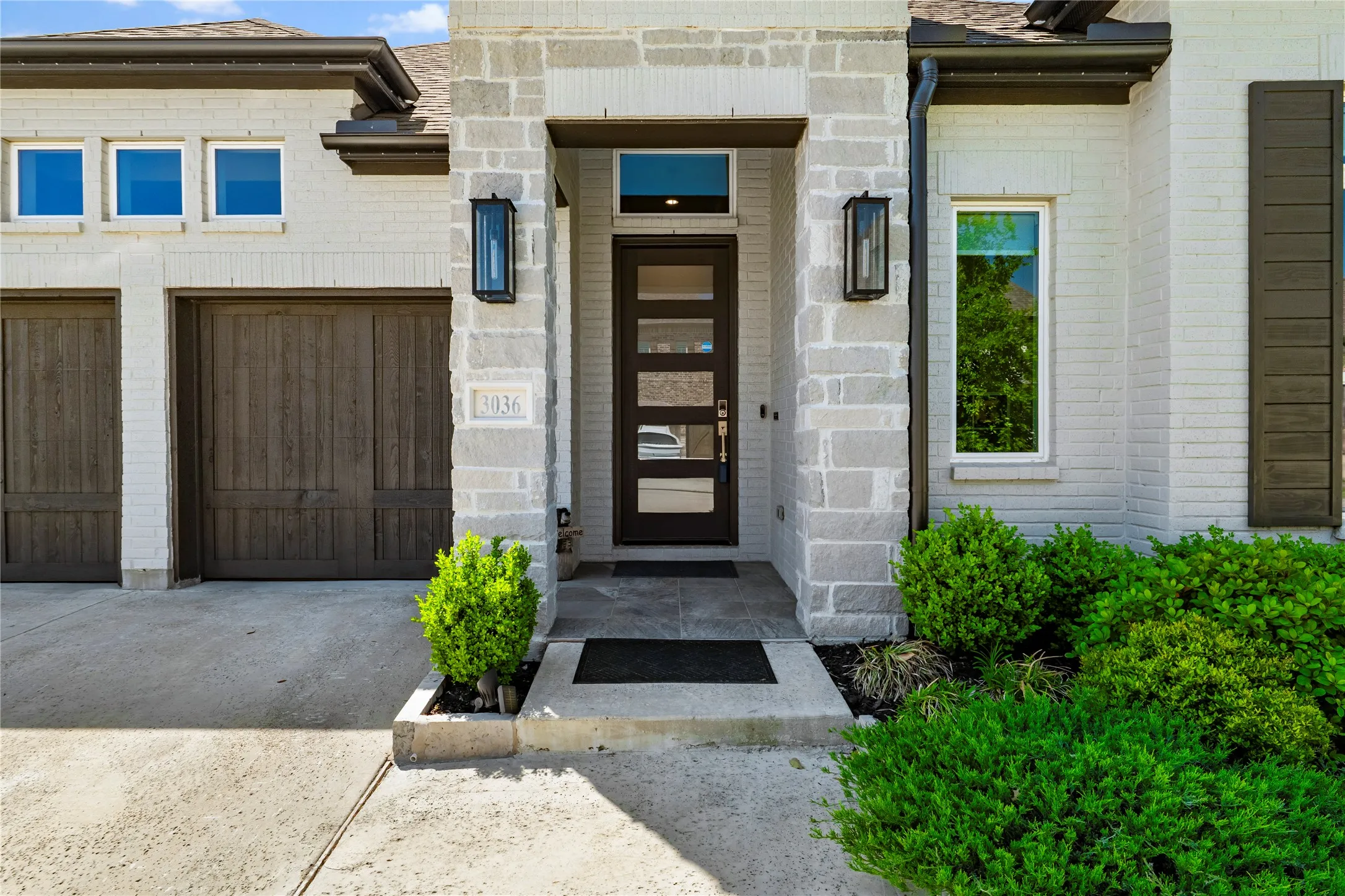 Entrance to property featuring driveway and brick siding