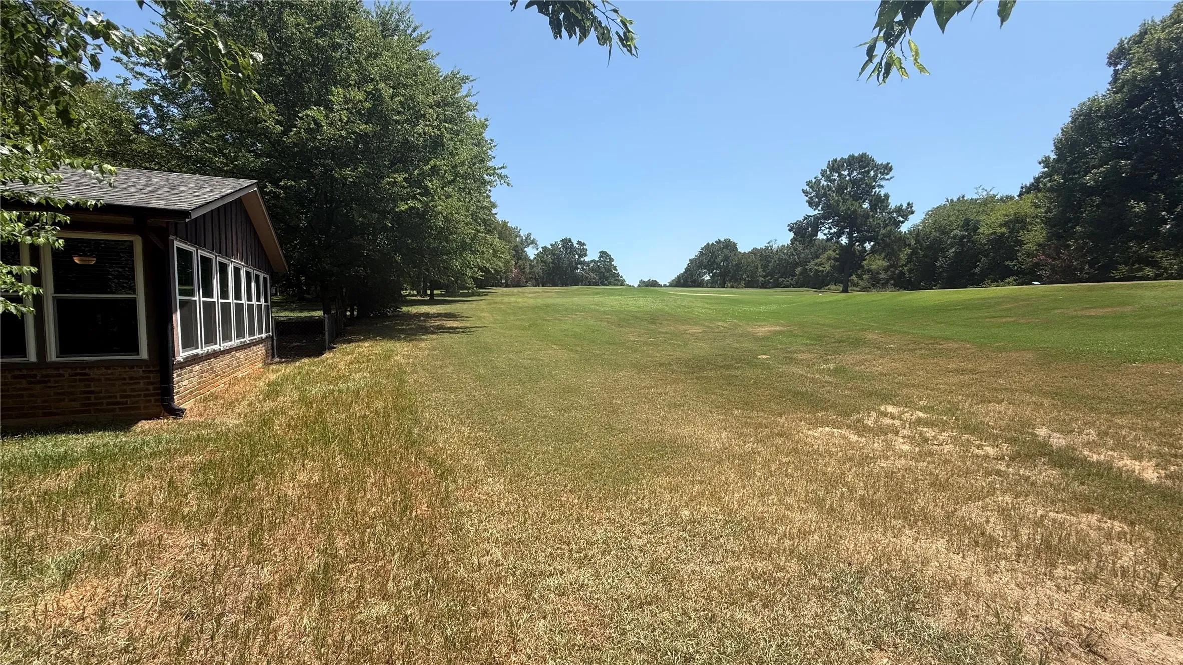 Expansive lawn area with mature trees bordering a golf​​‌​​​​‌​​‌‌​‌‌​​​‌‌​‌​‌​‌​​​‌​​ course