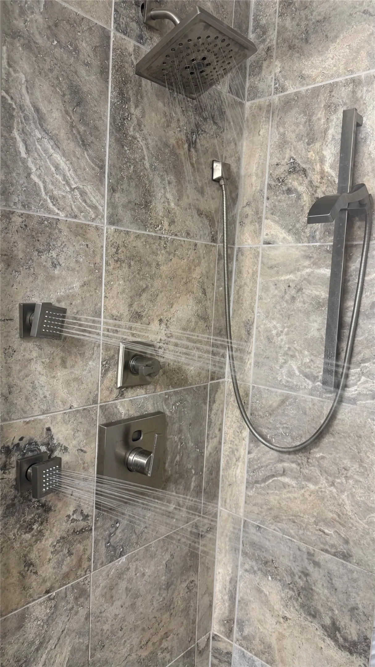Shower enclosure featuring large format stone-look tile