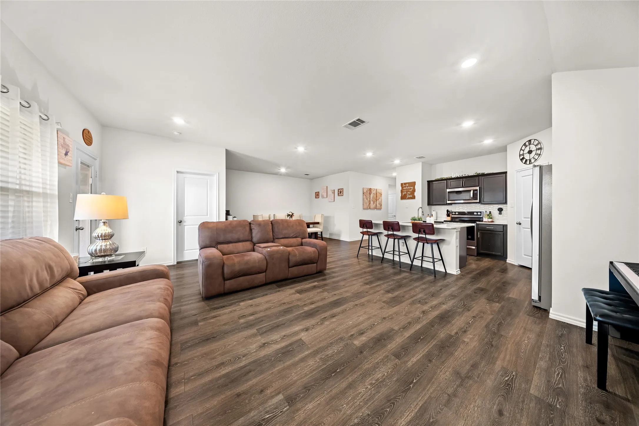 Open-concept living space featuring wood-finish flooring, recessed lighting, and white walls