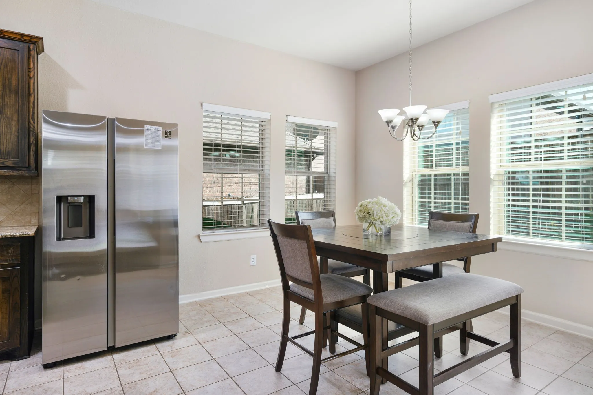Breakfast area with tiled flooring, multiple windows, and a chandelier