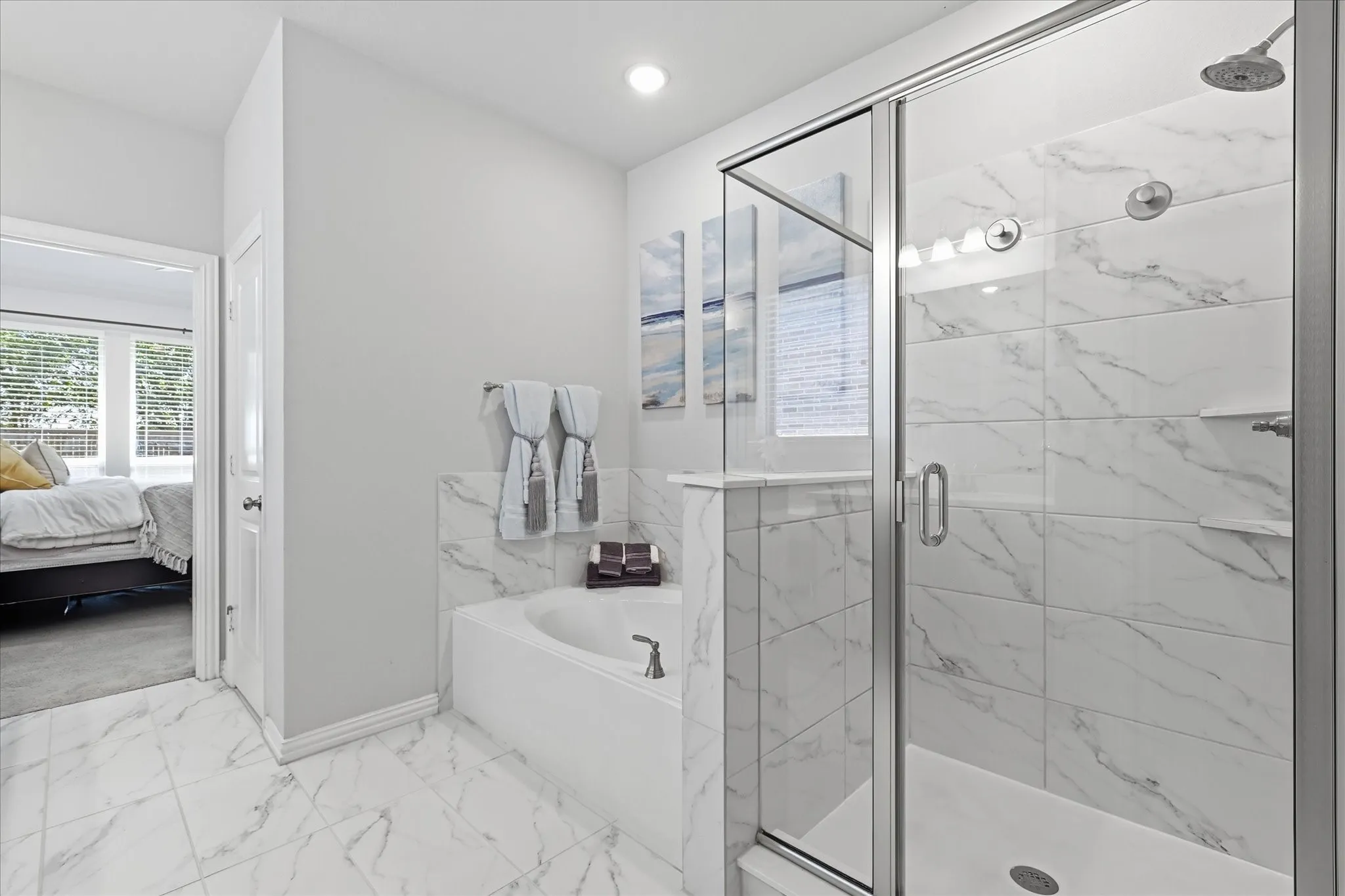 Dual vanity with undermount sinks, gray cabinetry, and white countertops and separate tub and walk in shower with large closet