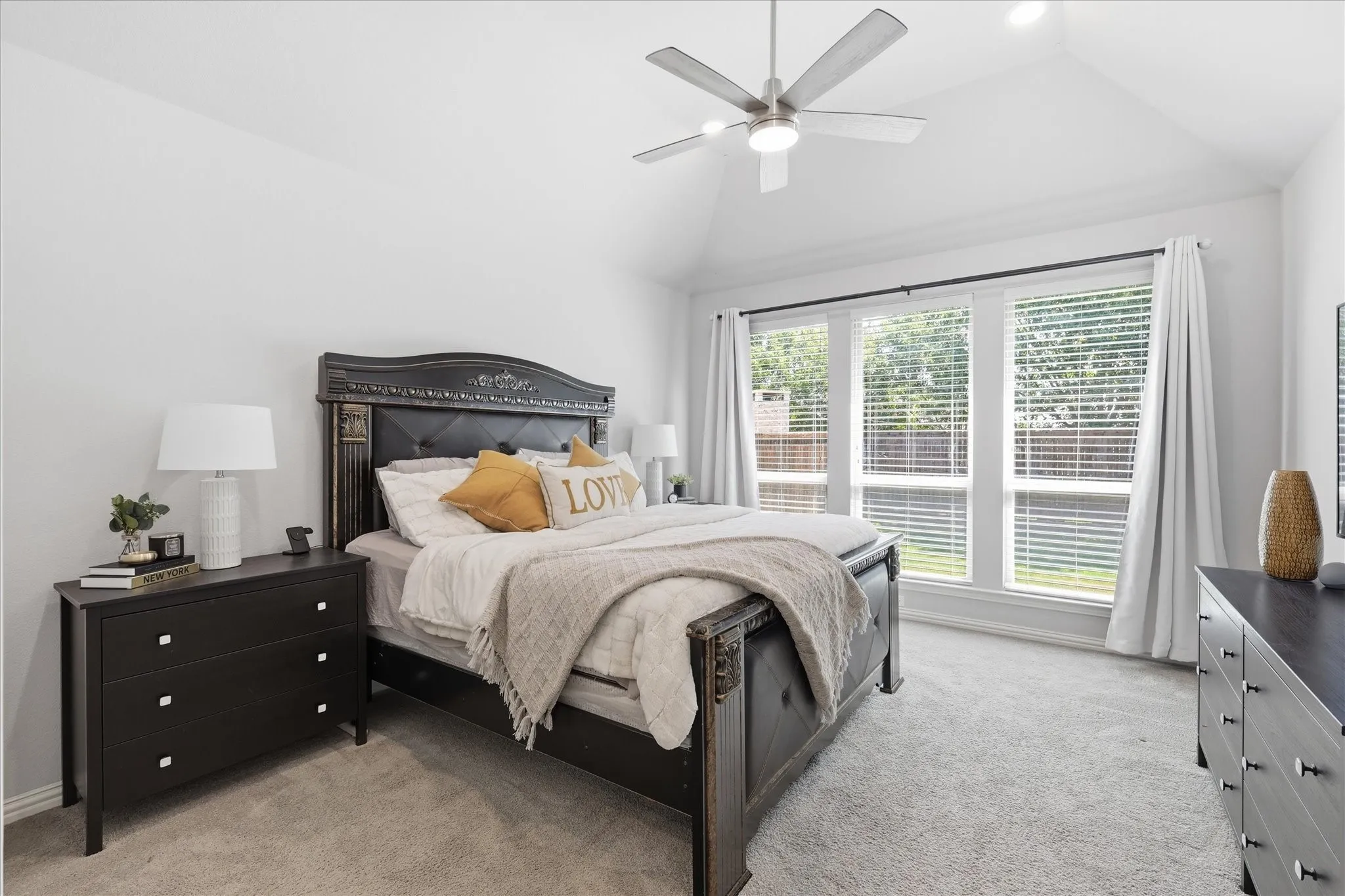 Large primary bedroom featuring a vaulted ceiling with a ceiling fan, recessed lighting with sitting room and large amount of natural light