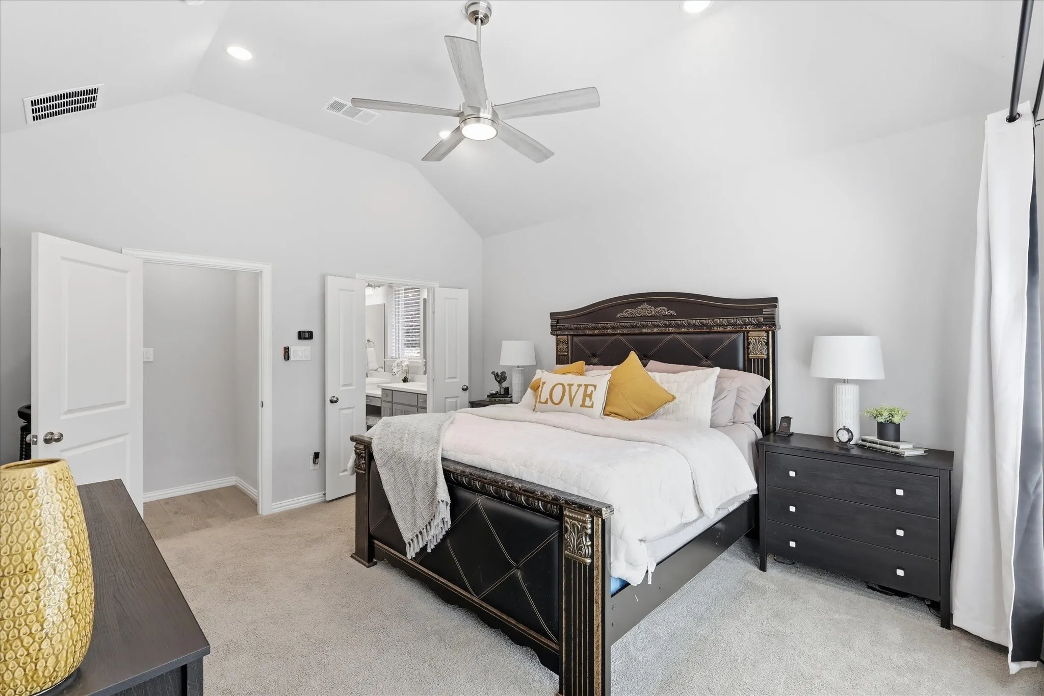 Large primary bedroom featuring a vaulted ceiling with a ceiling fan, recessed lighting with sitting room and large amount of natural light