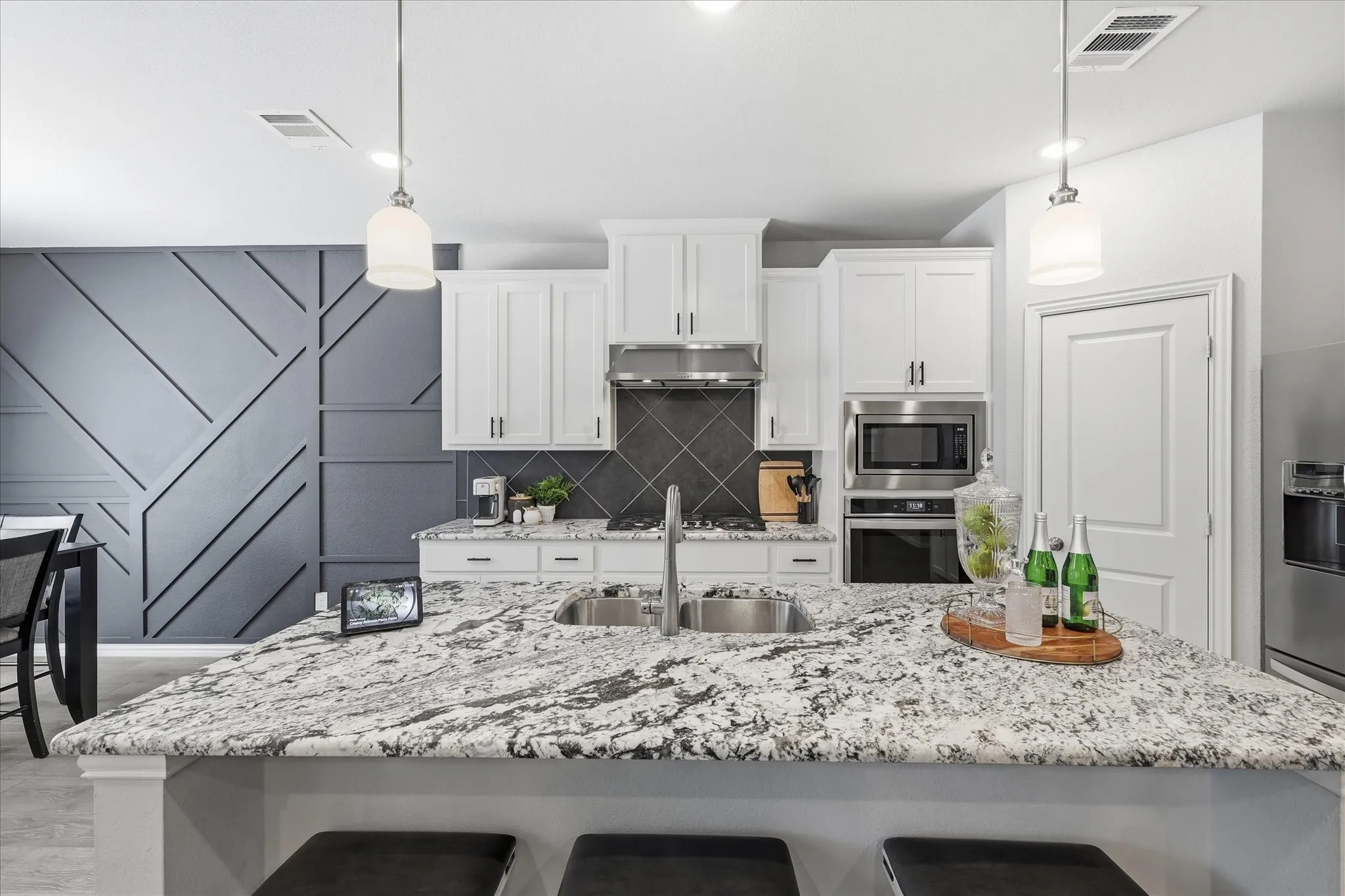 Kitchen island with a dual-basin stainless steel sink and a light-toned granite-style countertop