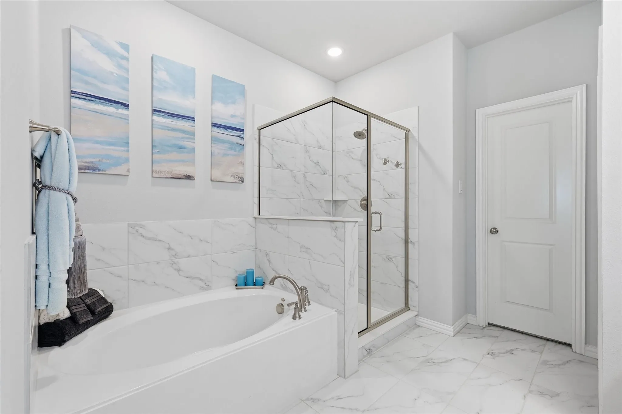 Dual vanity with undermount sinks, gray cabinetry, and white countertops and separate tub and walk in shower with large closet