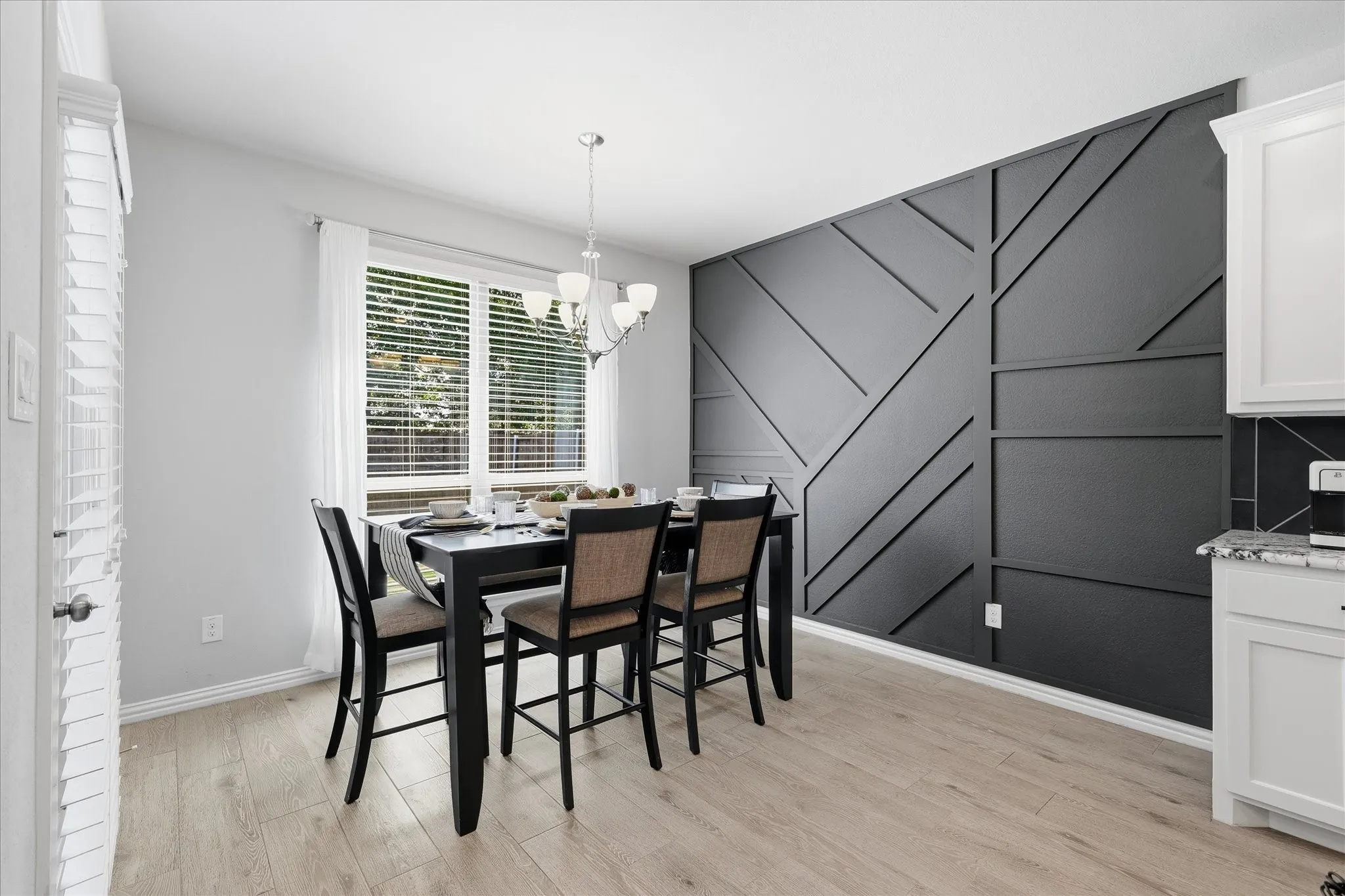 Dining area with a striking accent wall featuring geometric paneling