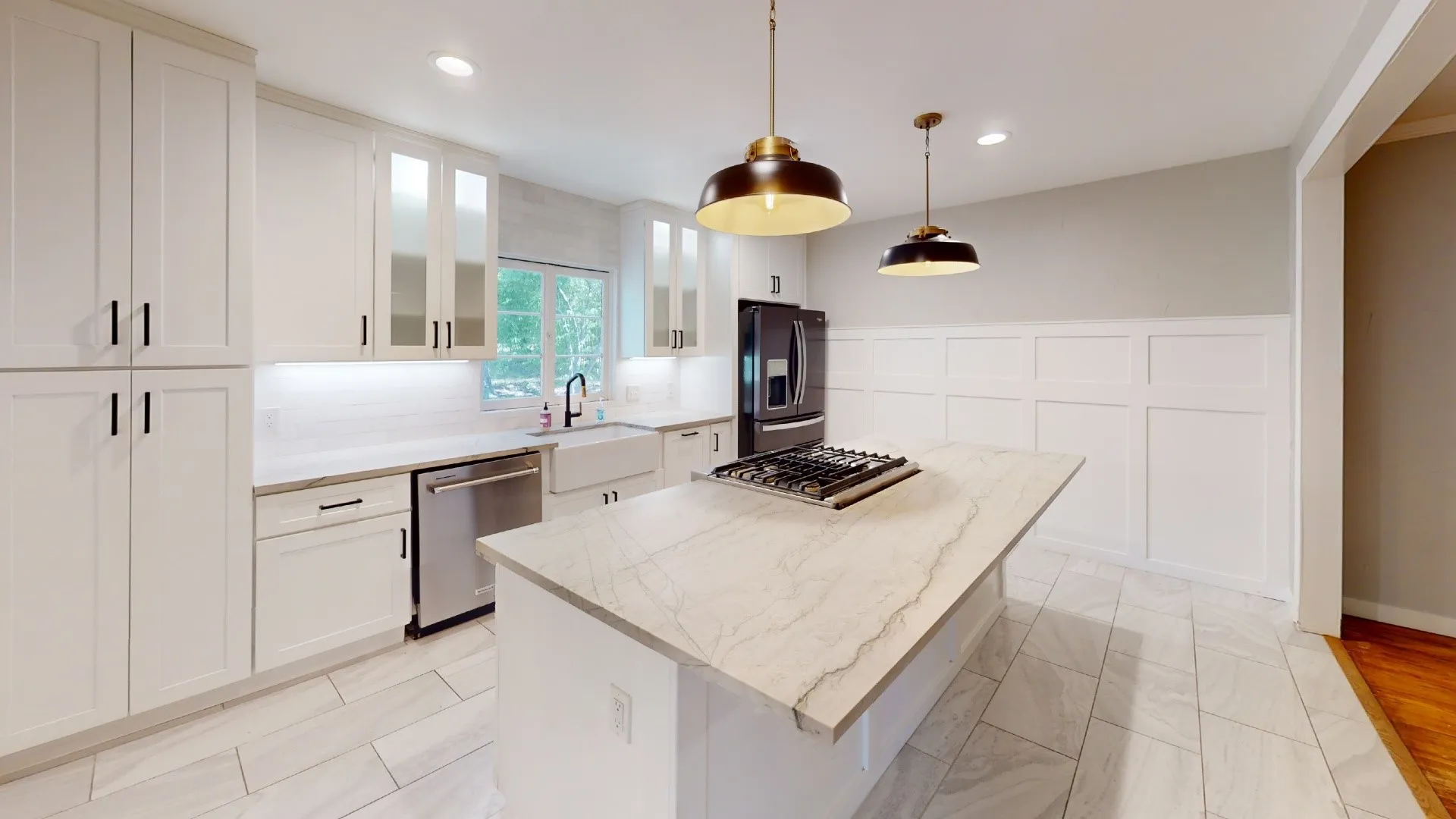Kitchen featuring a central island with a built-in gas cooktop, white shaker-style cabinetry, and light-toned countertops