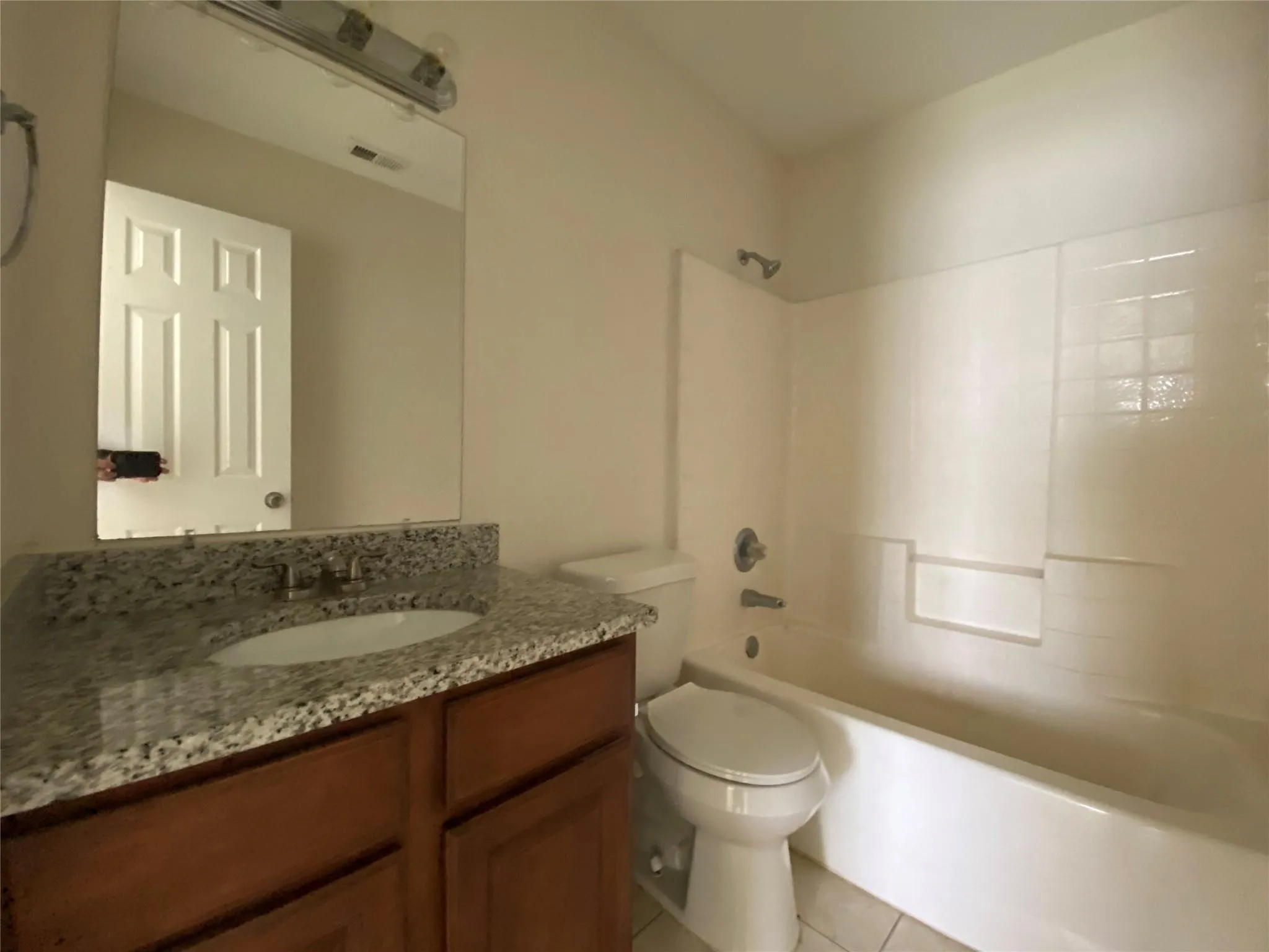Full bathroom with tile patterned floors, shower / washtub combination, vanity, and toilet