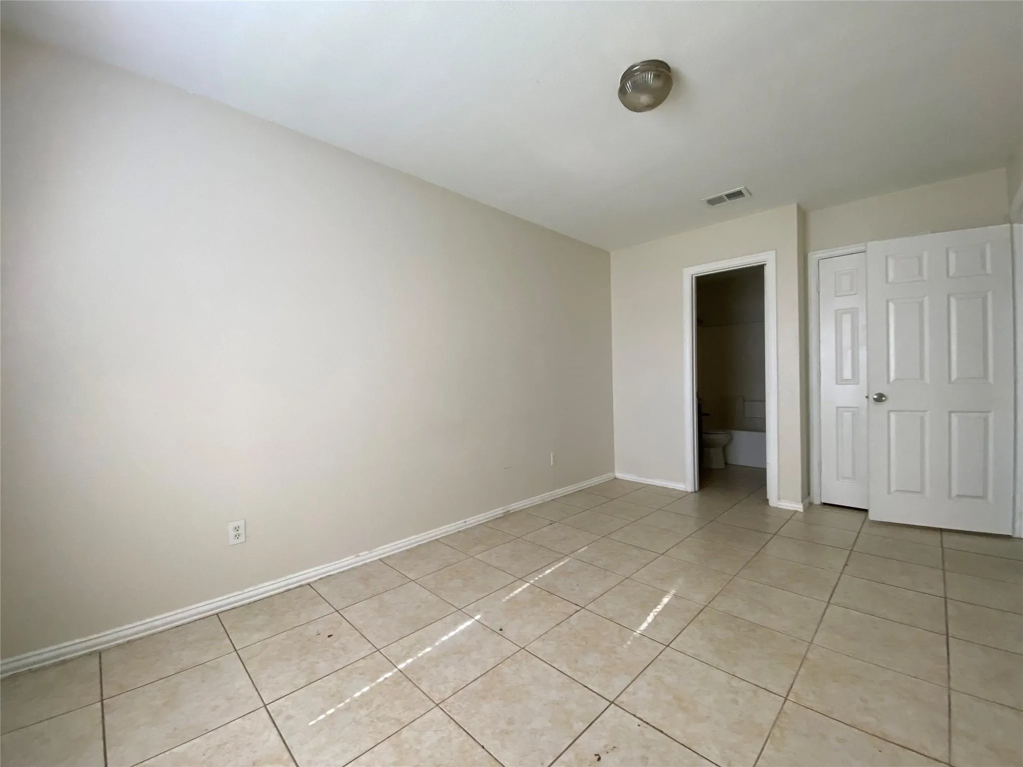 Unfurnished bedroom with light tile patterned floors and a closet
