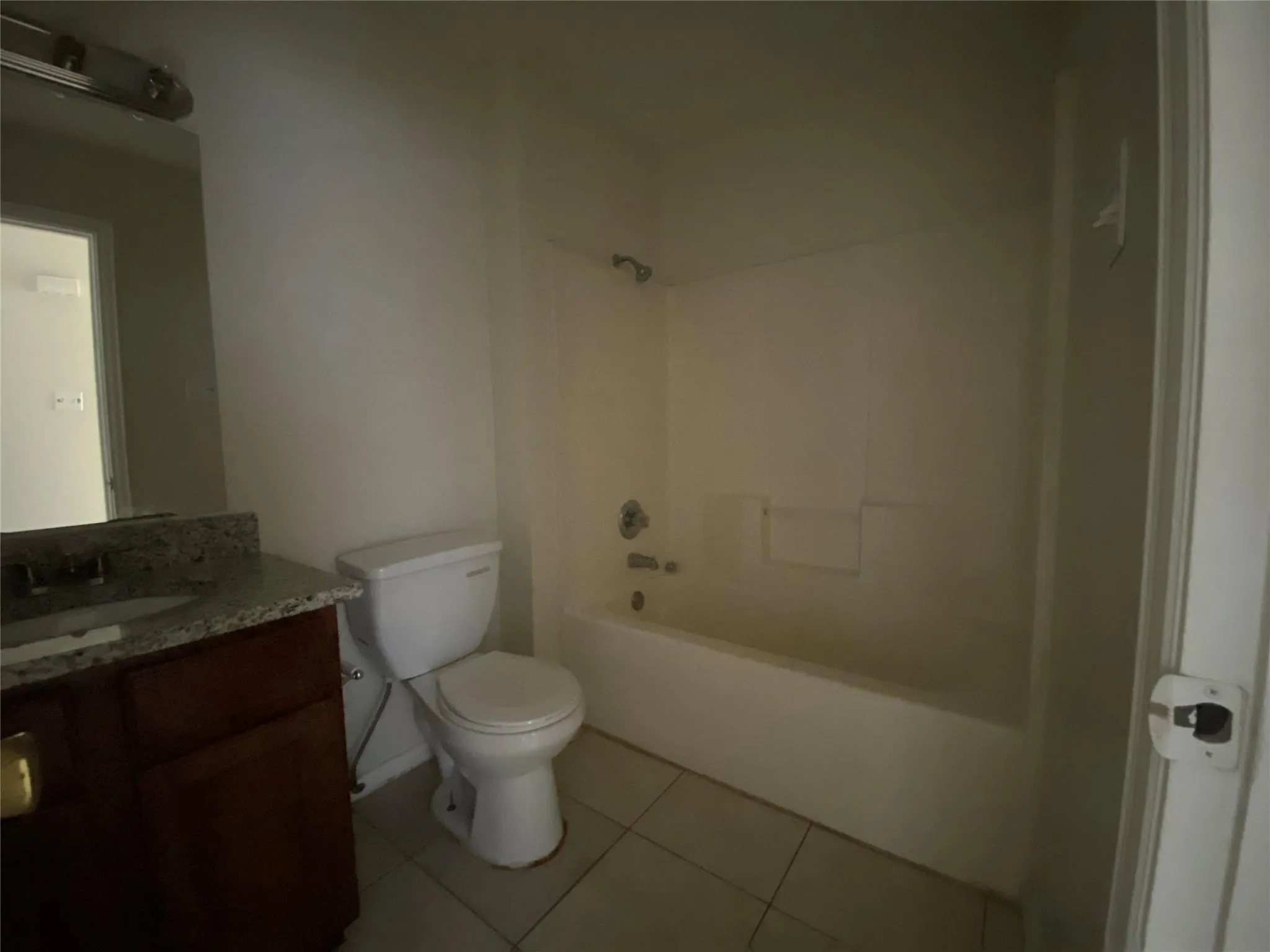 Full bathroom with toilet, vanity, tile patterned floors, and shower / washtub combination