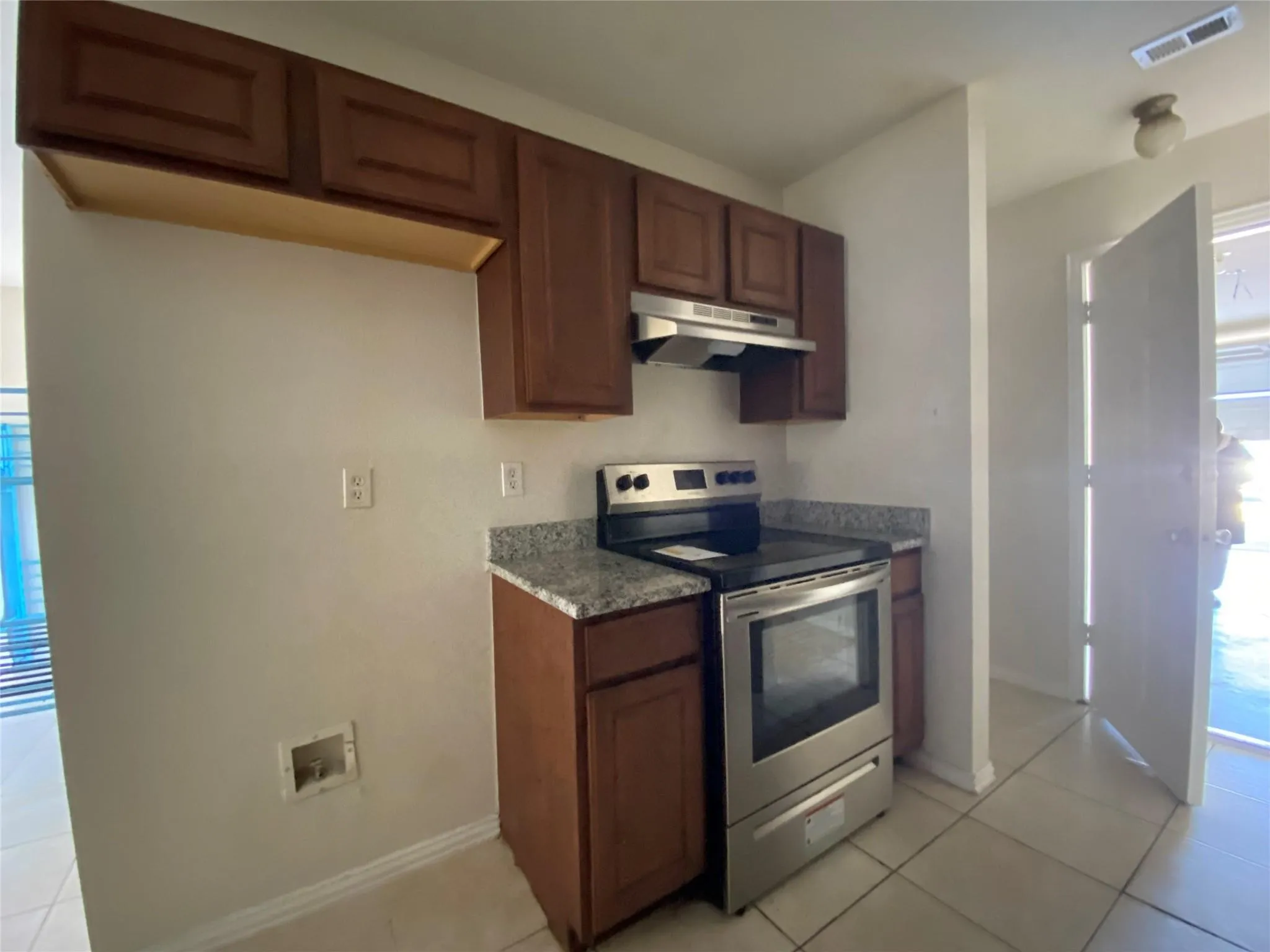 Kitchen featuring stainless steel range with electric stovetop and light tile patterned floors