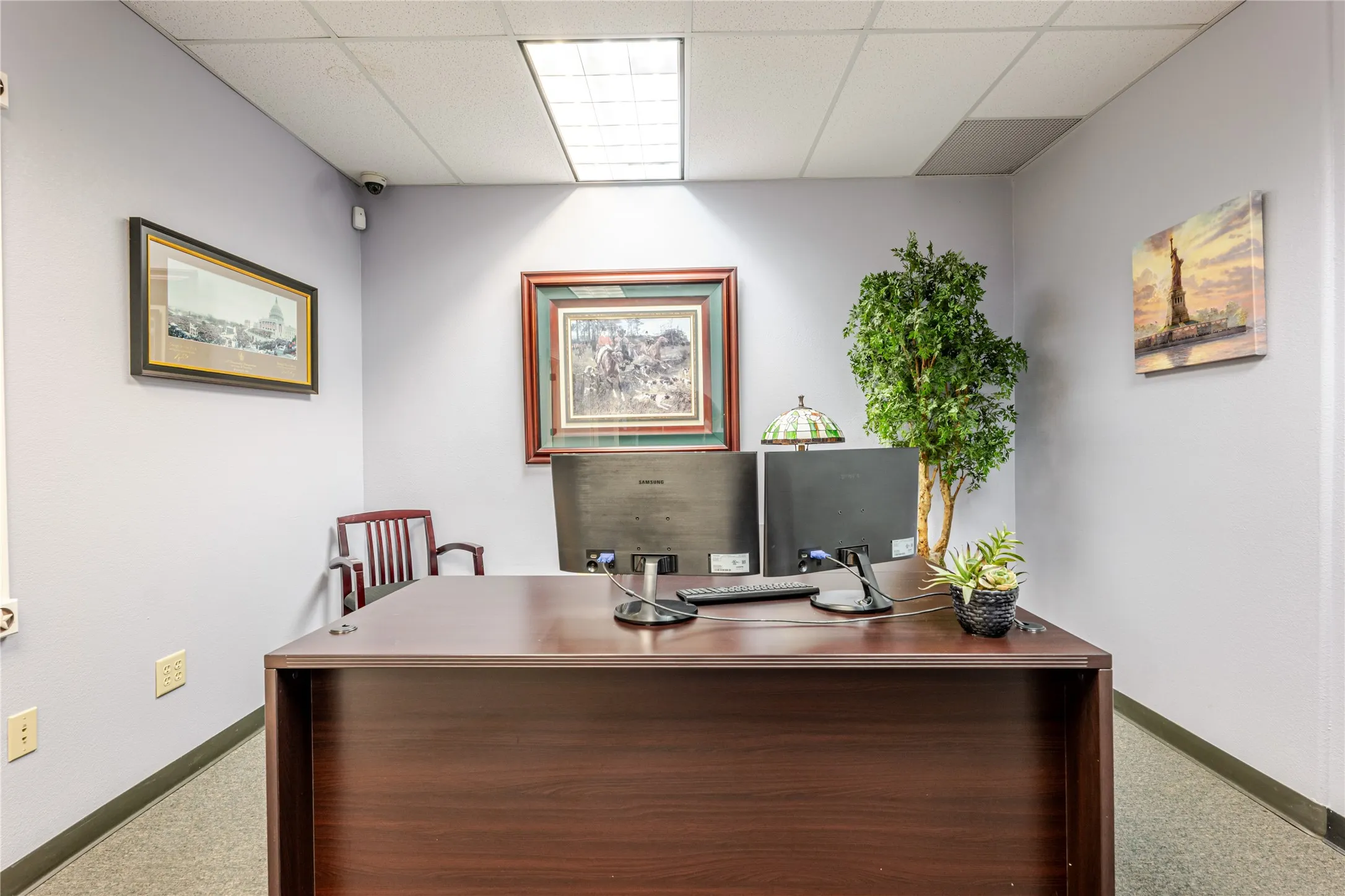 Office space featuring light-colored walls and grey carpet flooring