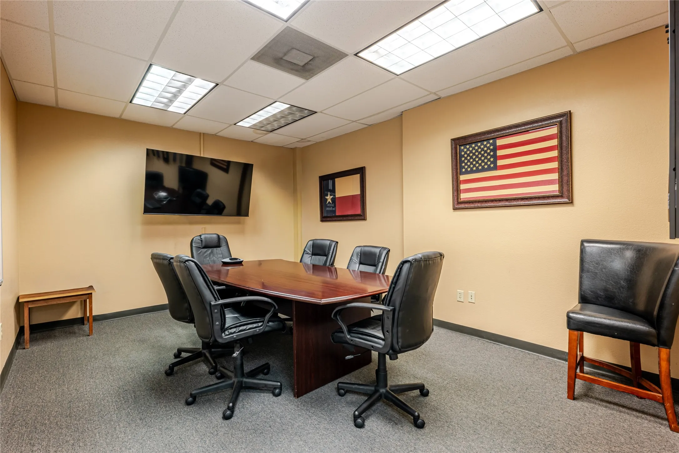 Conference room featuring neutral-toned walls, gray carpeting, and a drop ceiling with recessed lighting