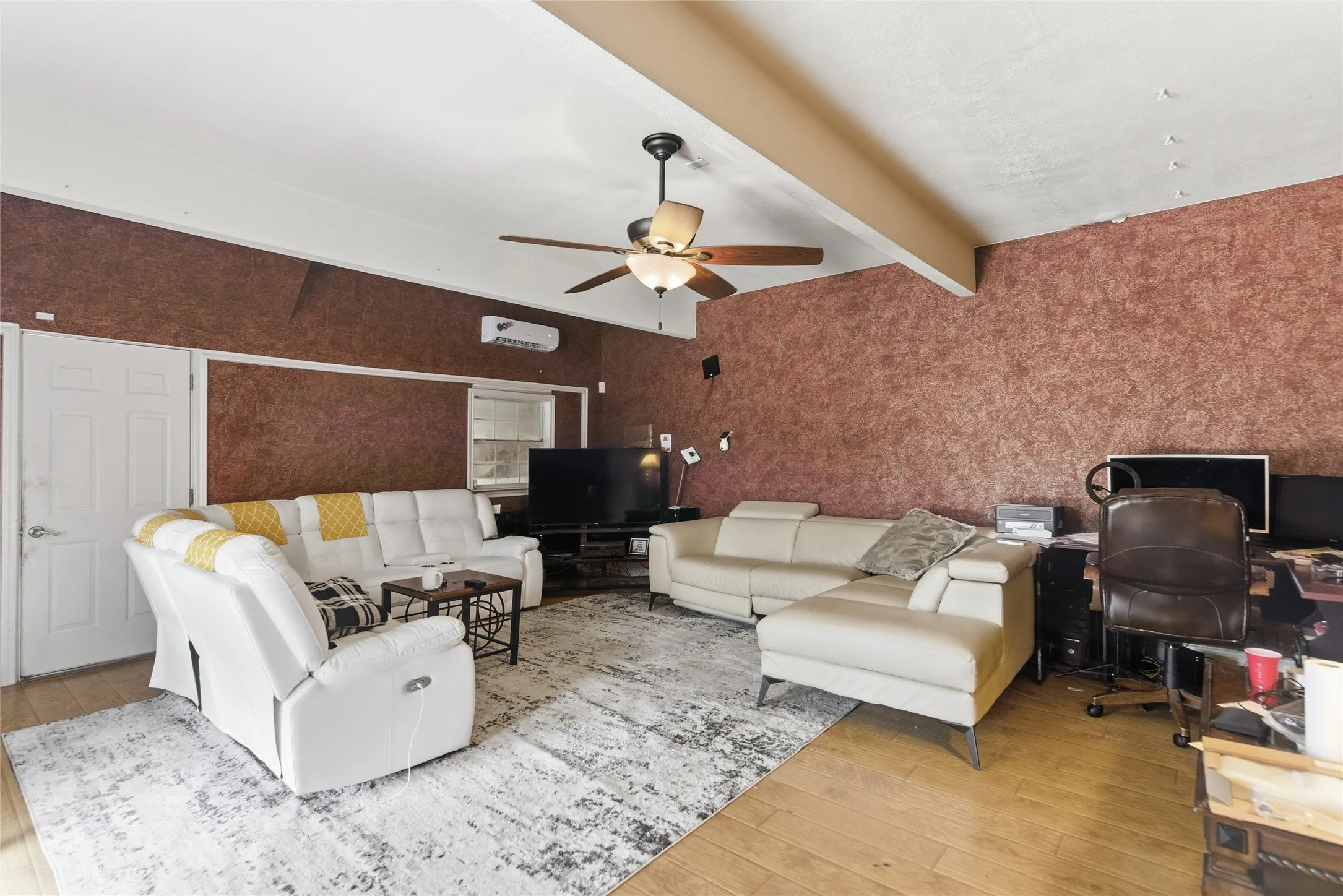 Spacious room featuring textured wall finishes and wood-finish flooring