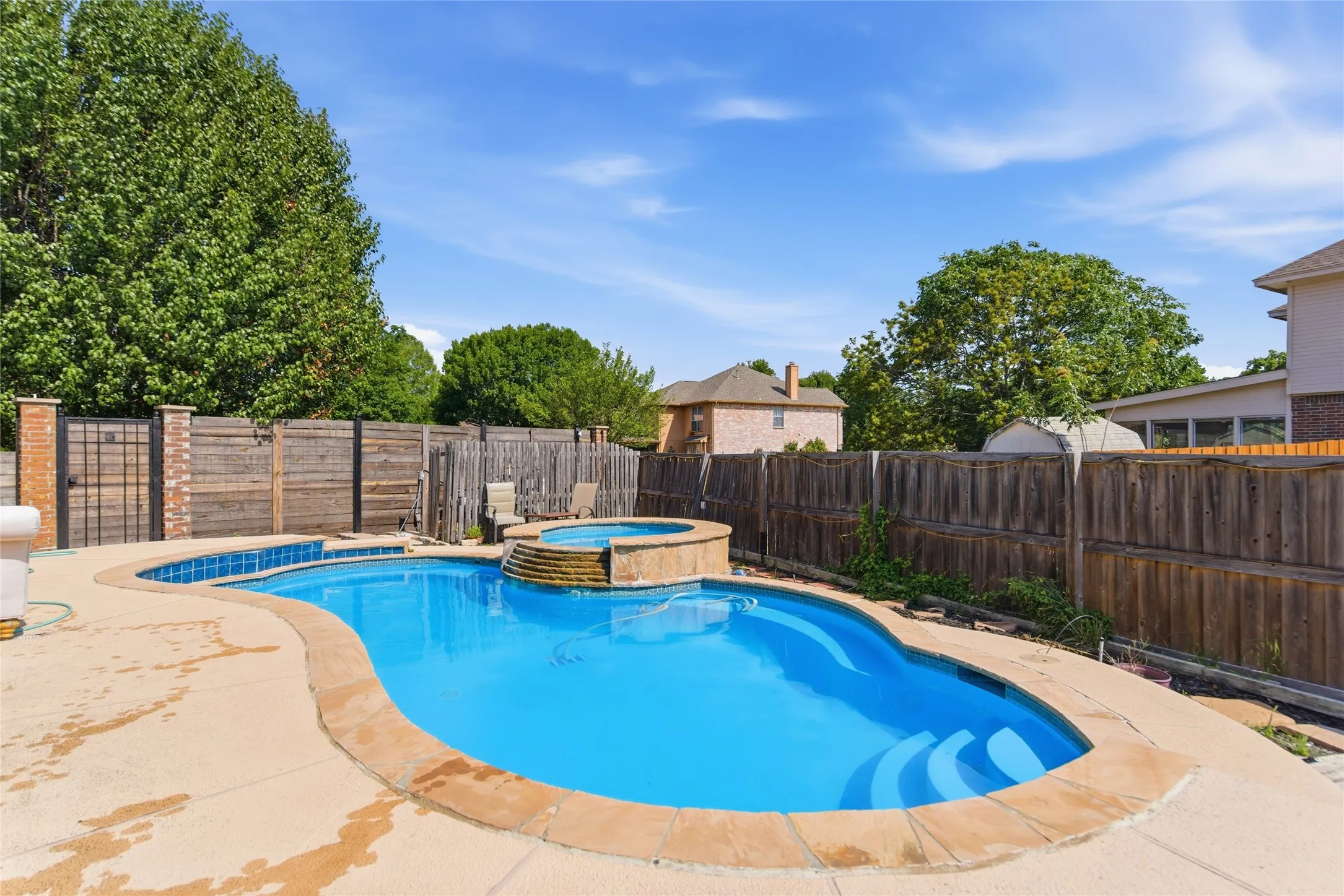 Kidney-shaped swimming pool featuring an integrated spa