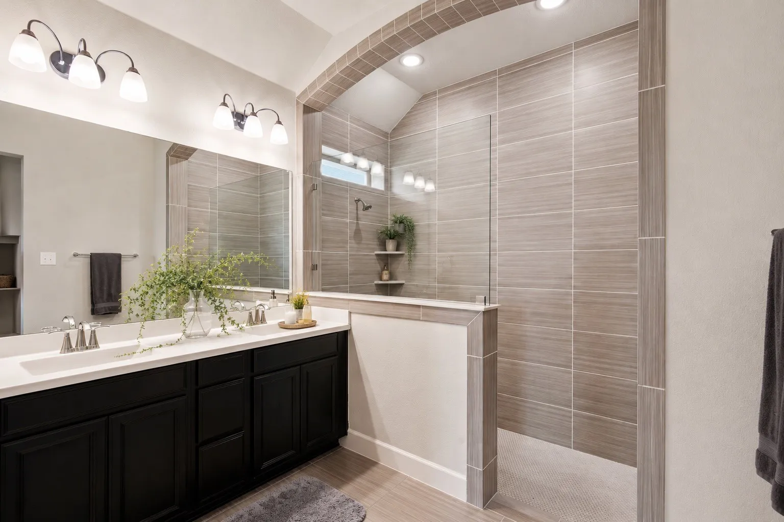 Bathroom featuring a dual vanity with dark wood cabinetry, white countertops, and brushed nickel fixtures