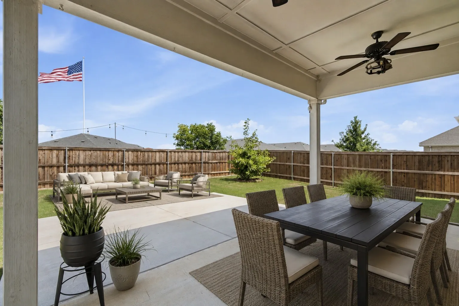 Expansive covered patio featuring a ceiling fan and ample concrete surfacing ( virtually staged)