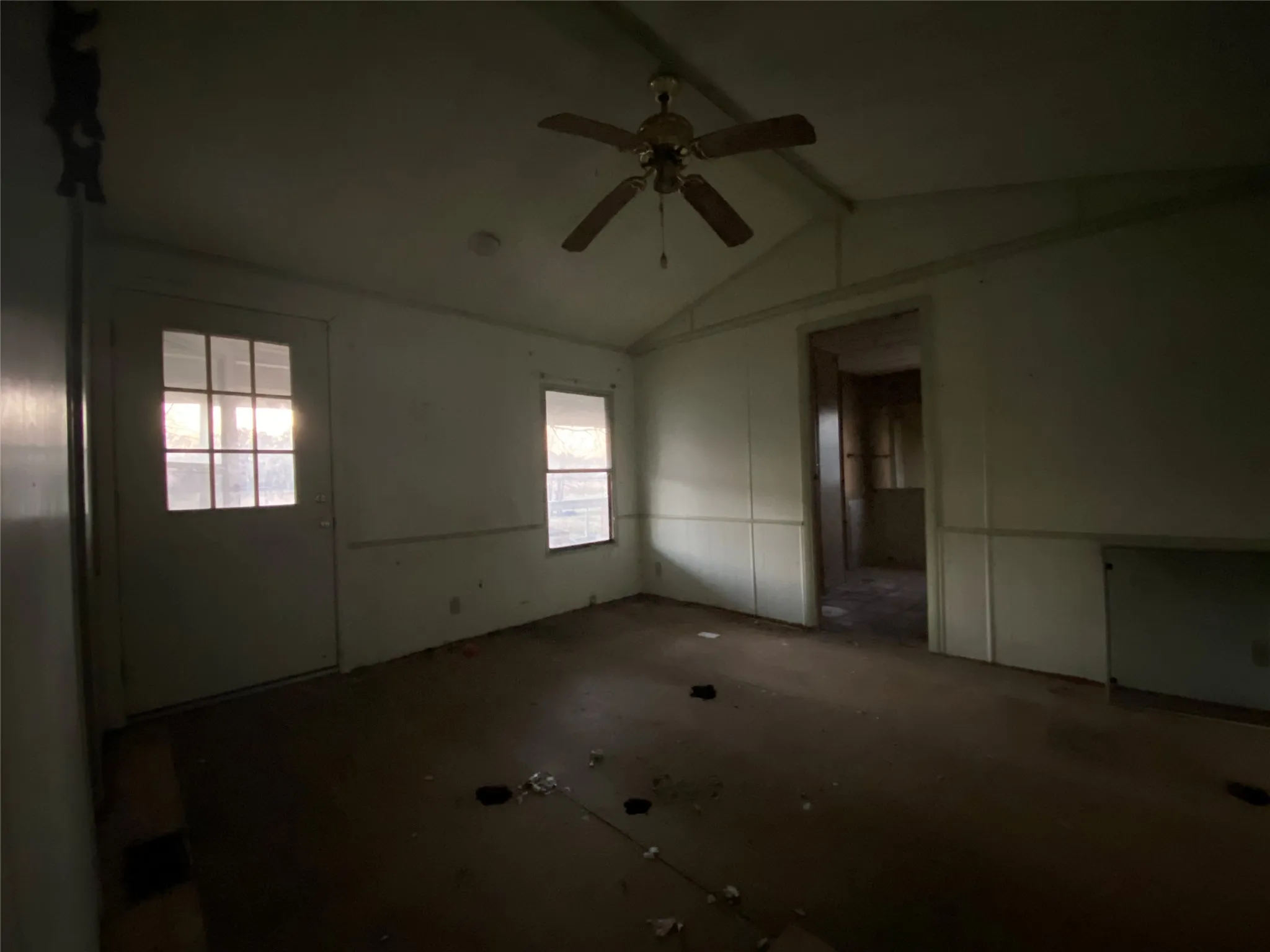 Empty room with ceiling fan and vaulted ceiling