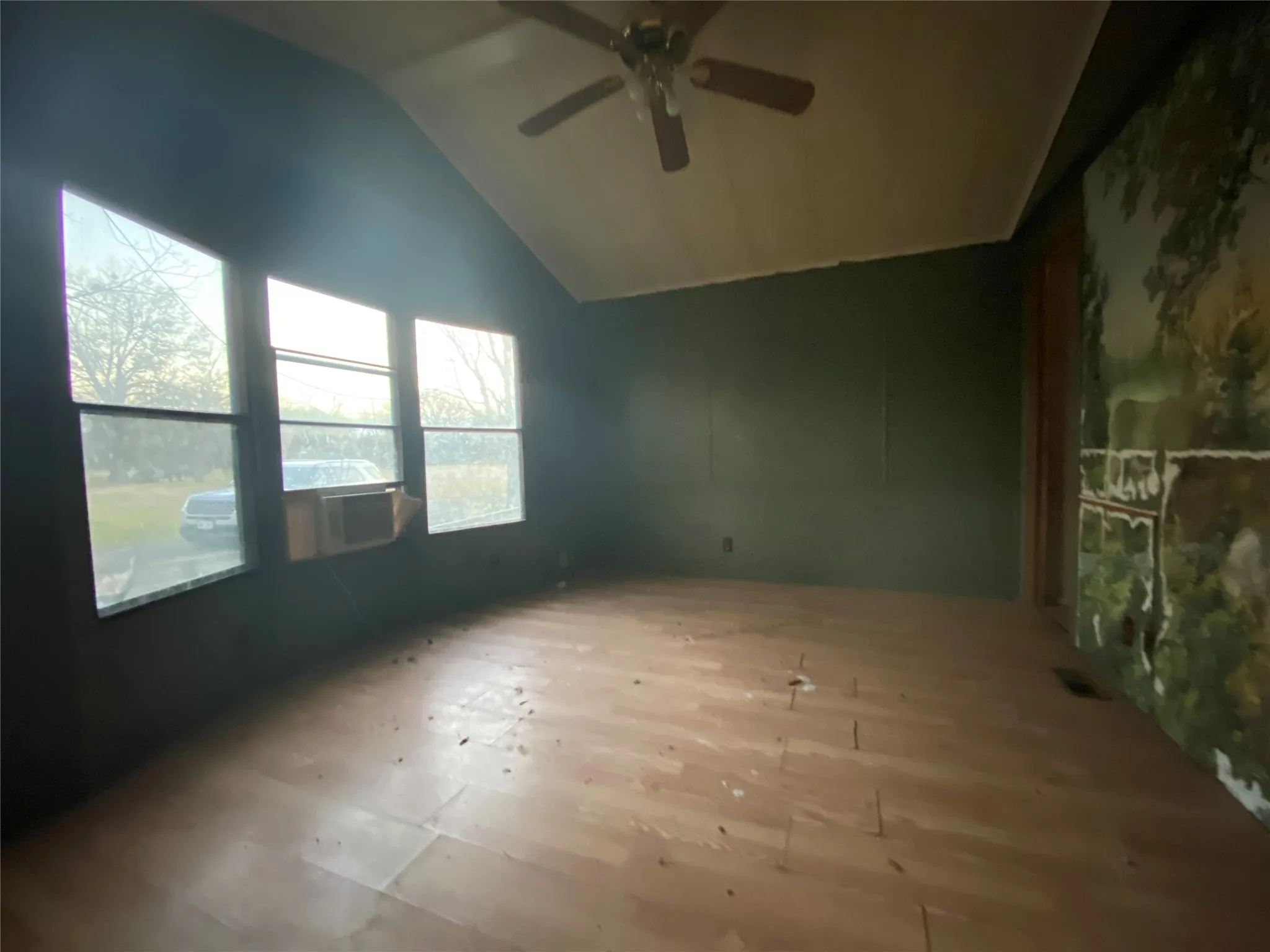 Unfurnished room with ceiling fan and lofted ceiling