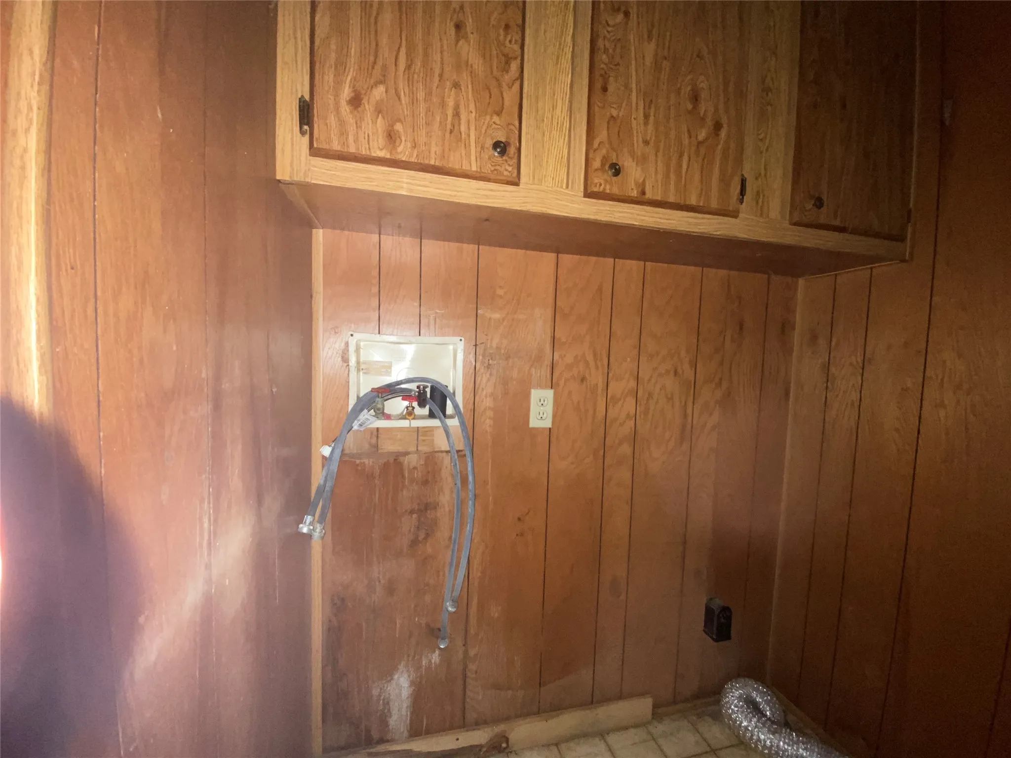 Laundry room with cabinets and wooden walls
