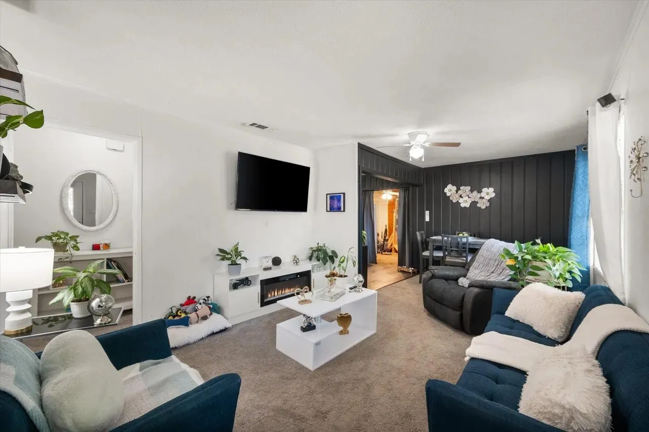 Living area featuring carpet flooring and a built-in media console with an electric fireplace