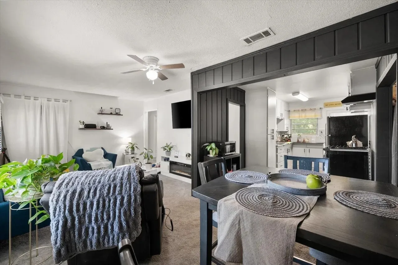 Open-concept living and dining area featuring a dark wood-finish dining table with seating