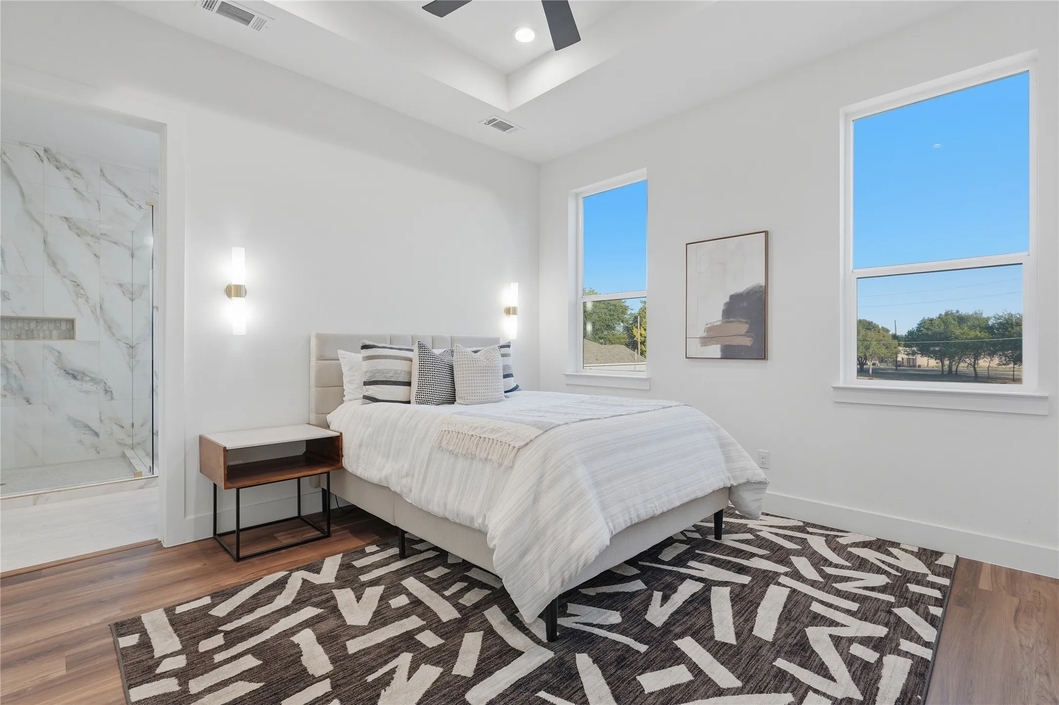 Wood-finish flooring, recessed lighting, and a tray ceiling