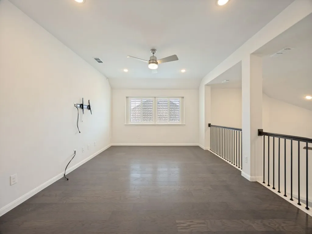 Open loft area featuring wood-finish flooring, recessed lighting, and a ceiling fan