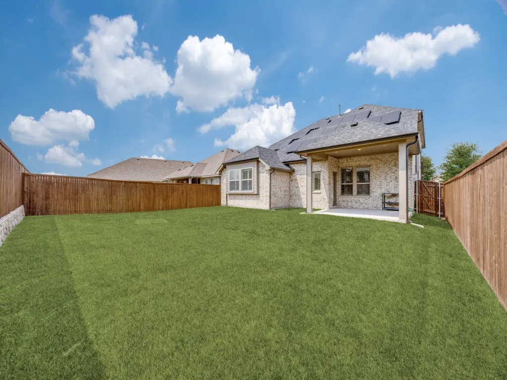 Expansive green lawn featuring a full privacy fence