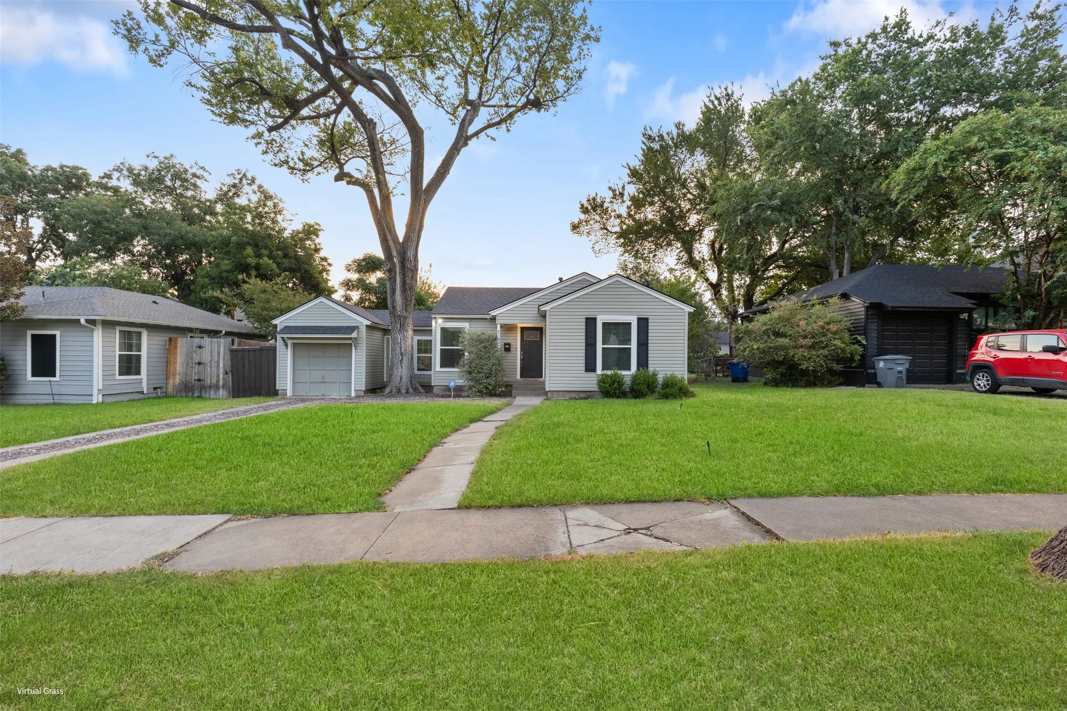 Light-colored siding exterior with dark shutters, front walkway, mature trees, and an attached garage