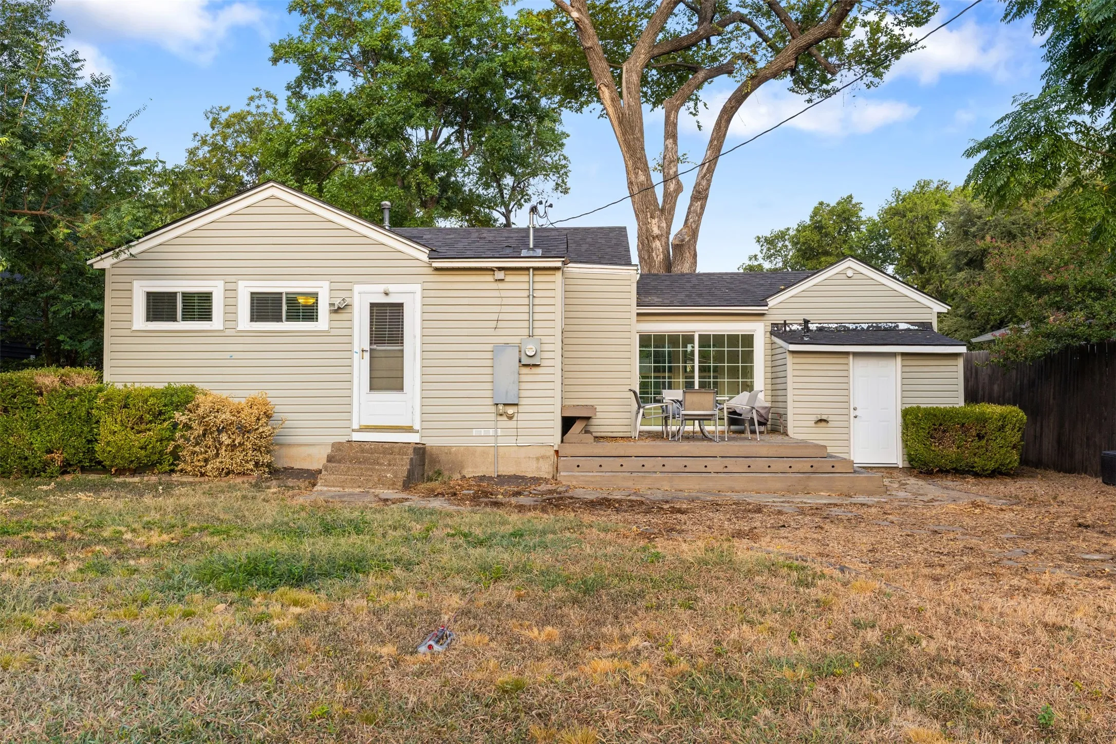 Rear exterior featuring siding, a raised deck, and a sliding glass door