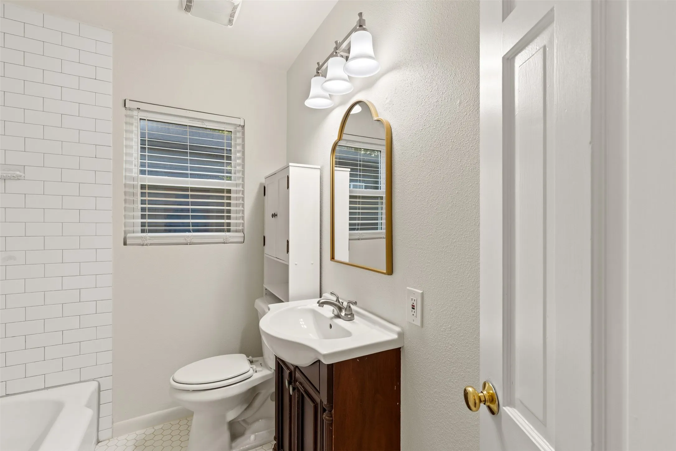White subway tile shower surround with a white tub