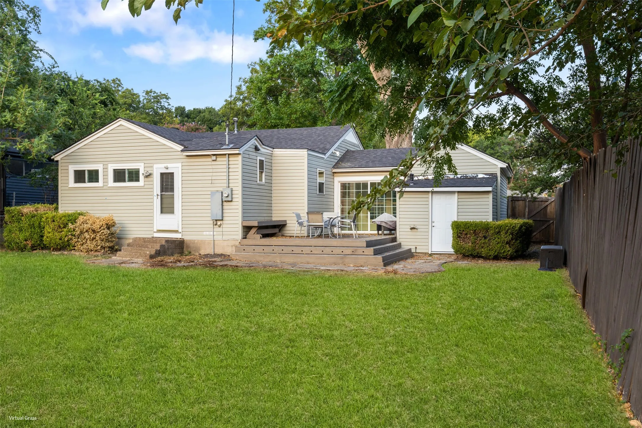 Expansive backyard featuring a manicured lawn, a multi-level deck, and a privacy fence
