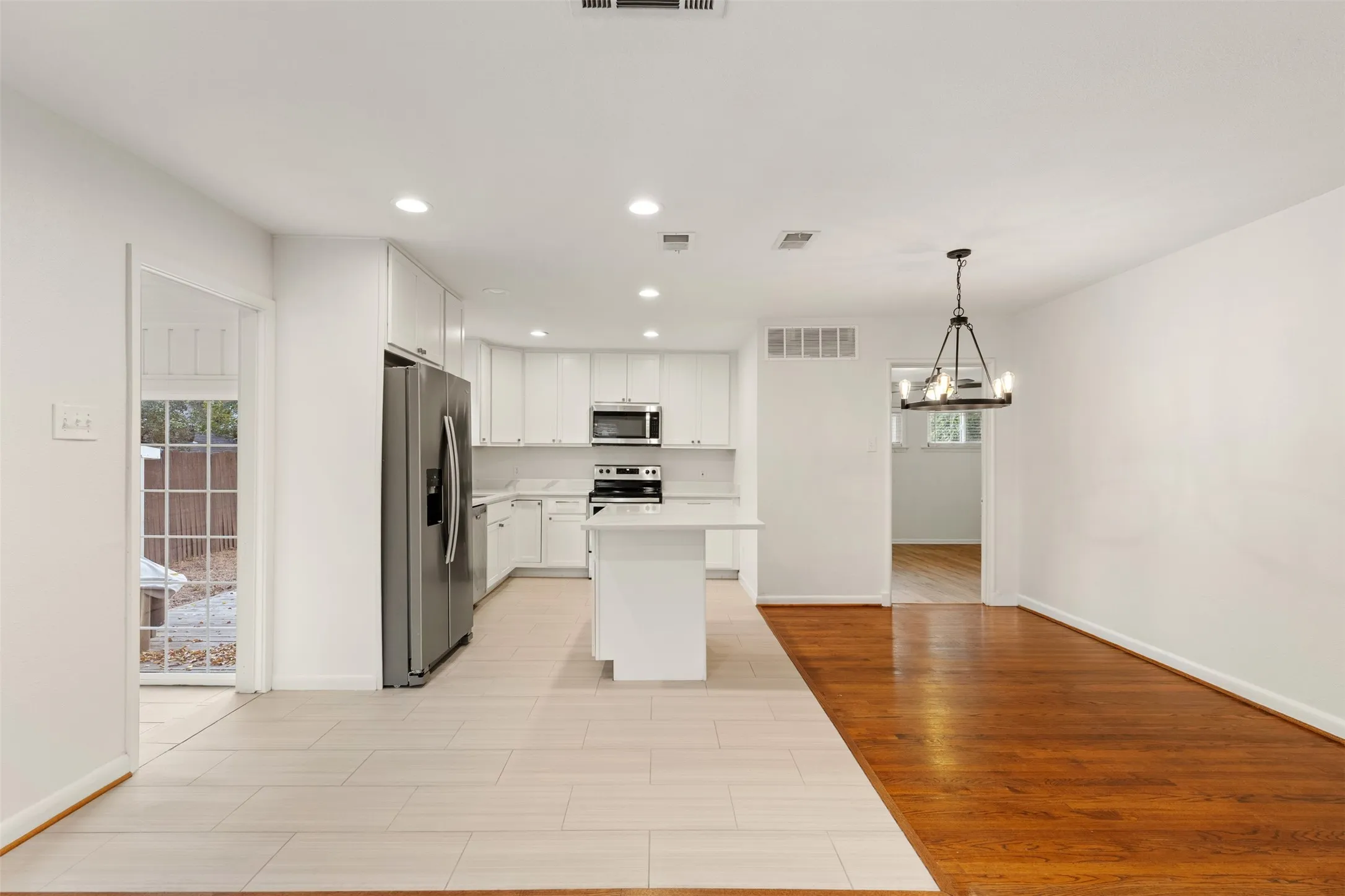 Modern kitchen featuring stainless steel appliances, white cabinetry, a central island, and recessed lighting