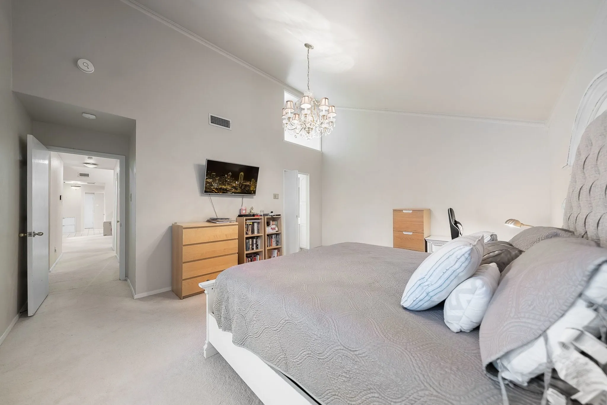 Vaulted primary bedroom with private backyard door access