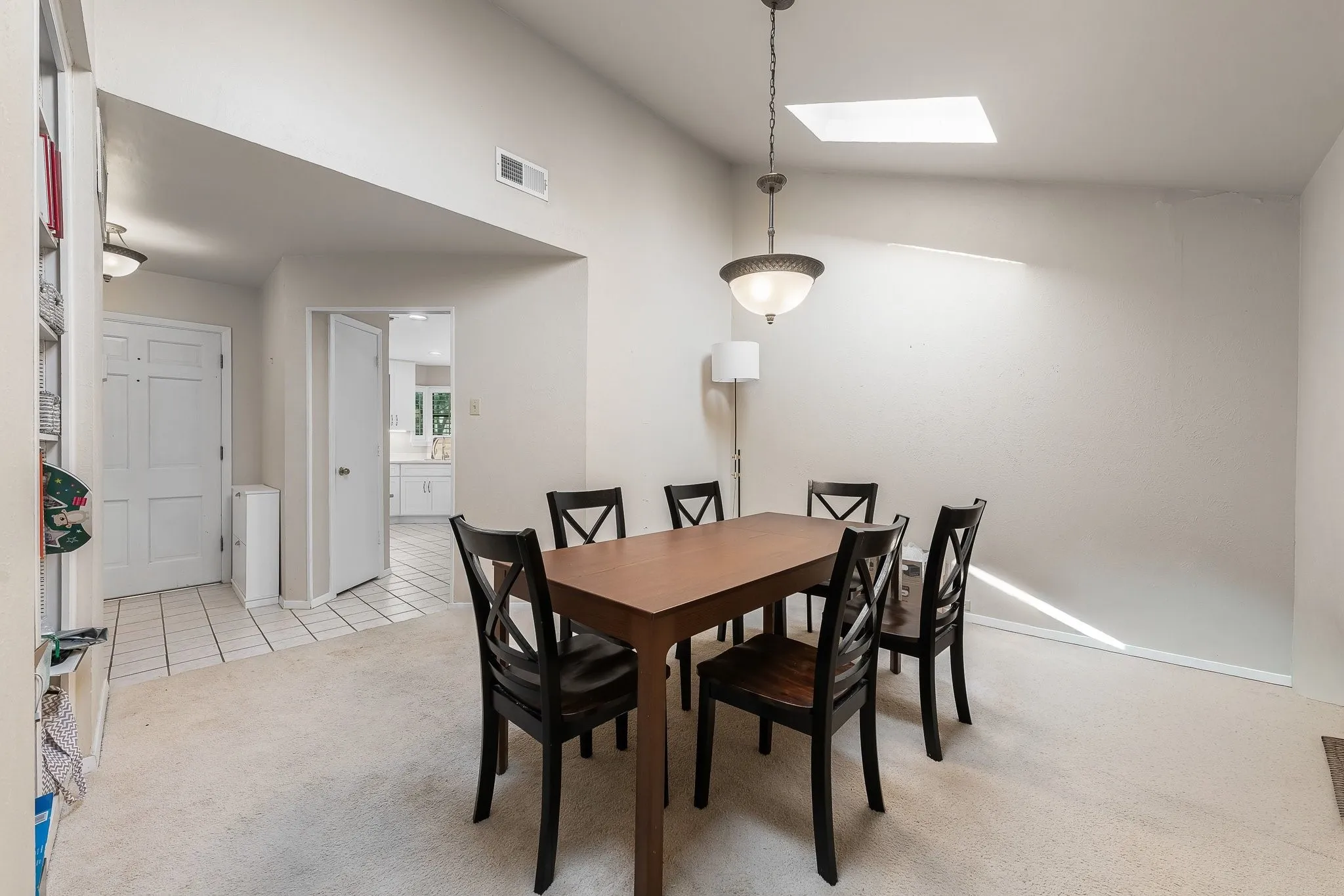 Naturally lit dining space, pendant.lighting, skylight, built-in shelving