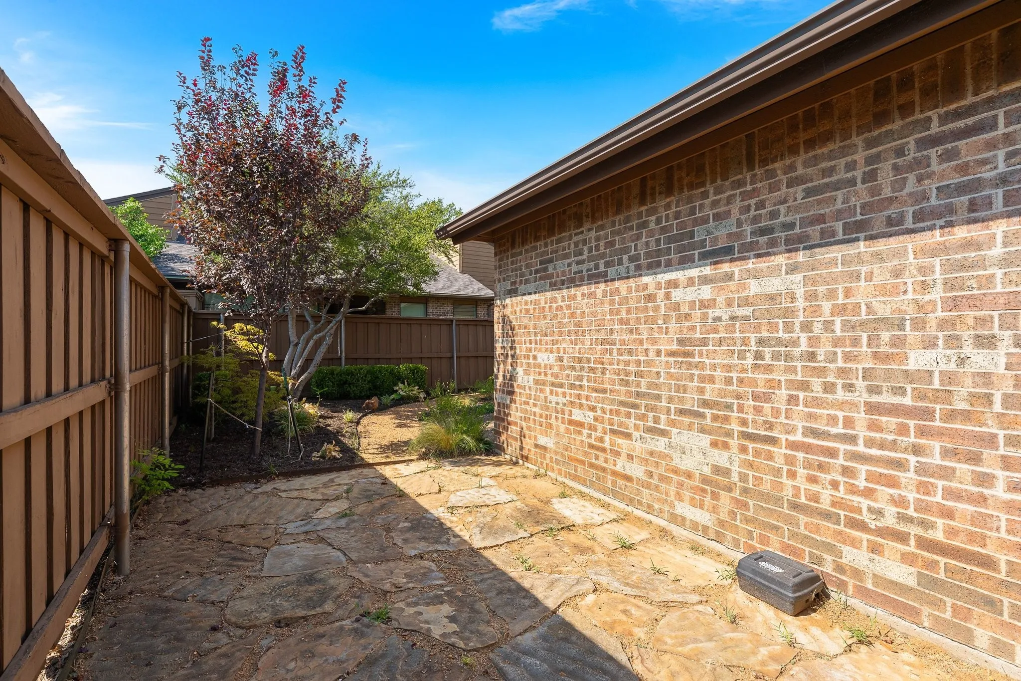 Fenced side yard with flagstone path and mature landscaping