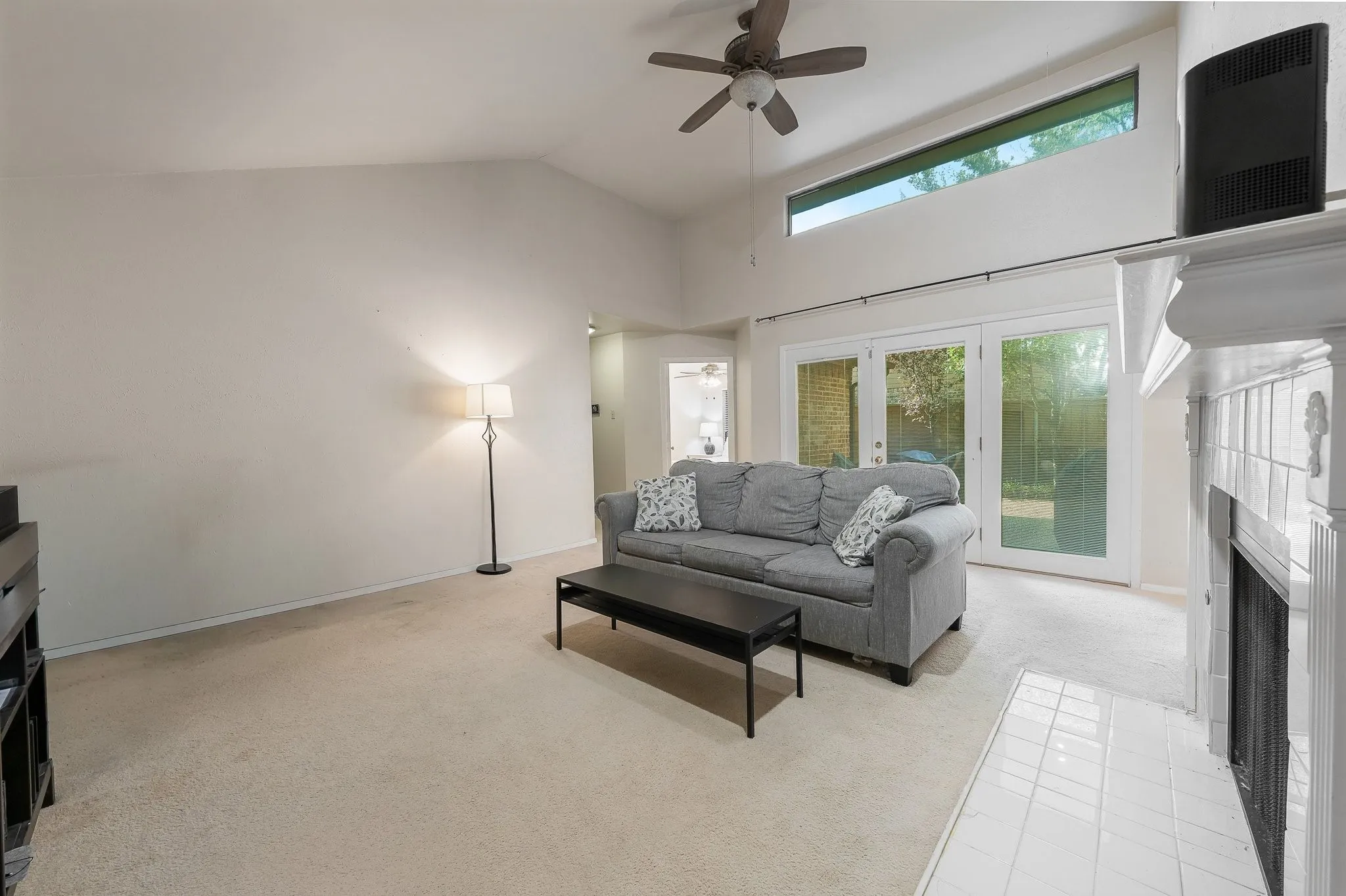 Vaulted living room with fireplace, French doors to backyard