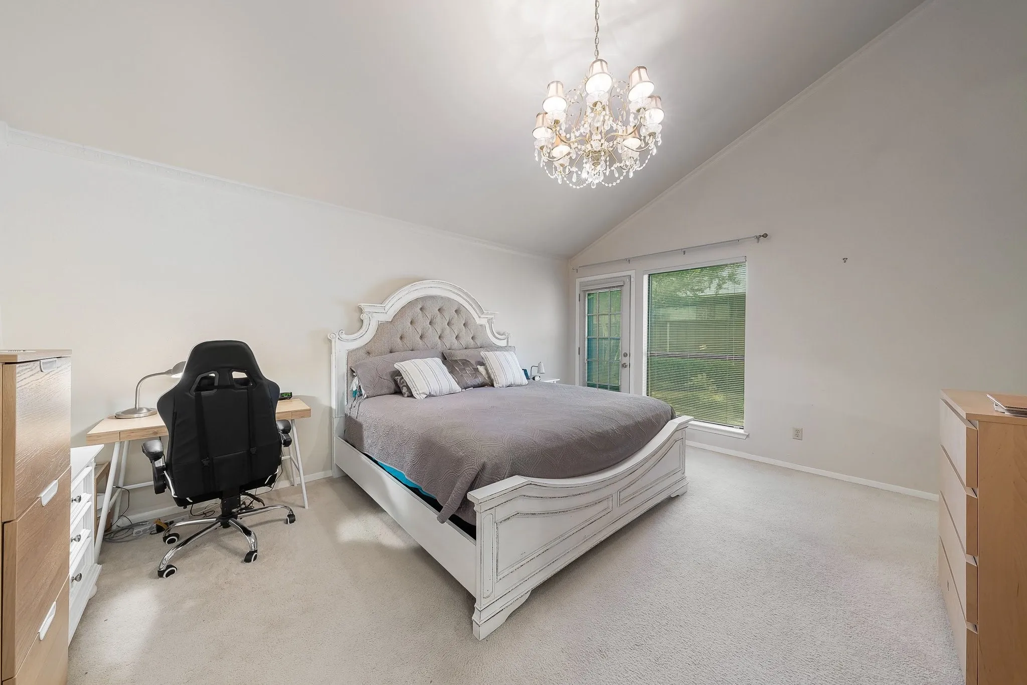 Vaulted primary bedroom with private backyard door access.