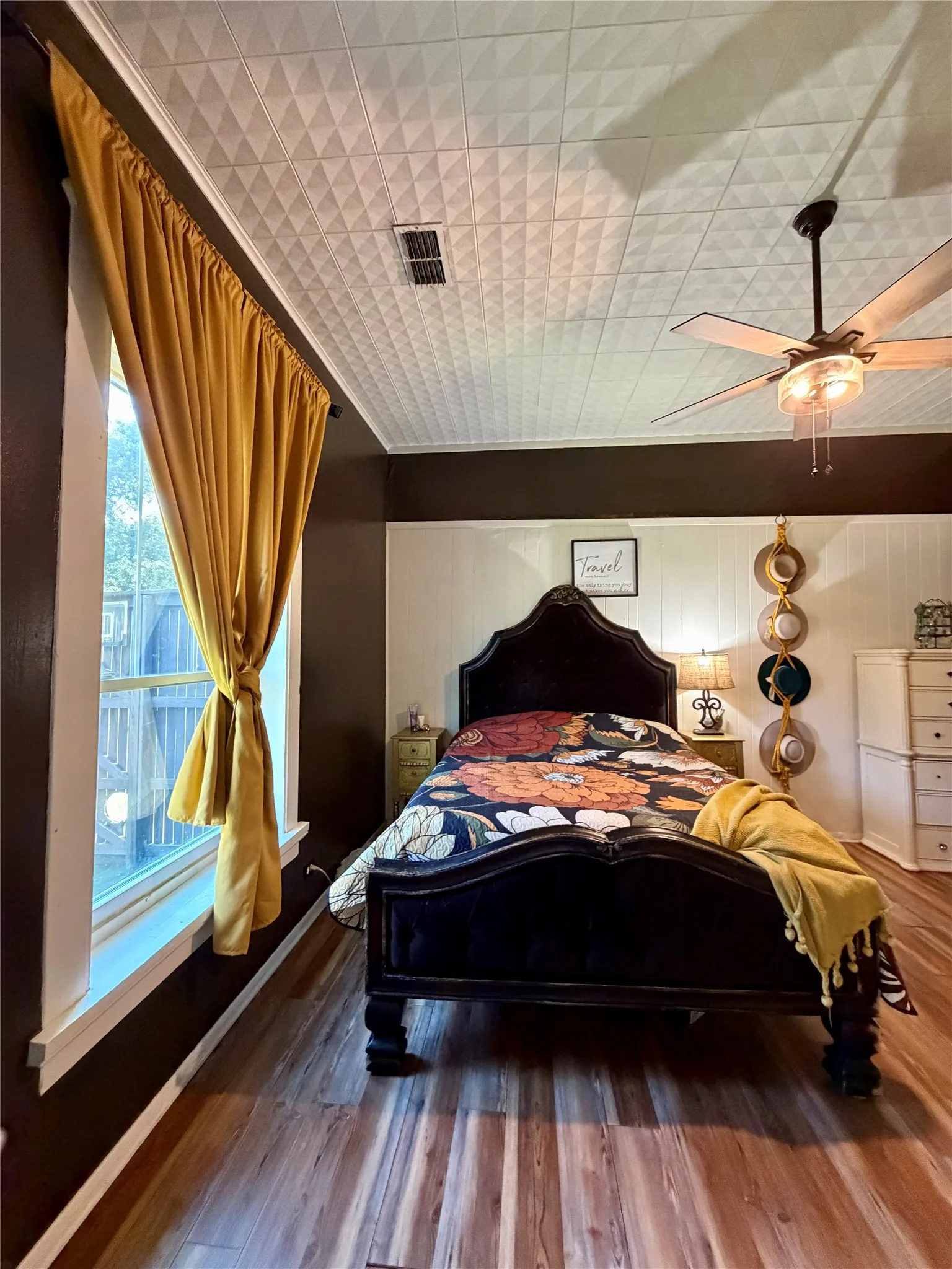 Bedroom featuring wood-finish flooring, a textured white ceiling, and a ceiling fan with integrated lighting