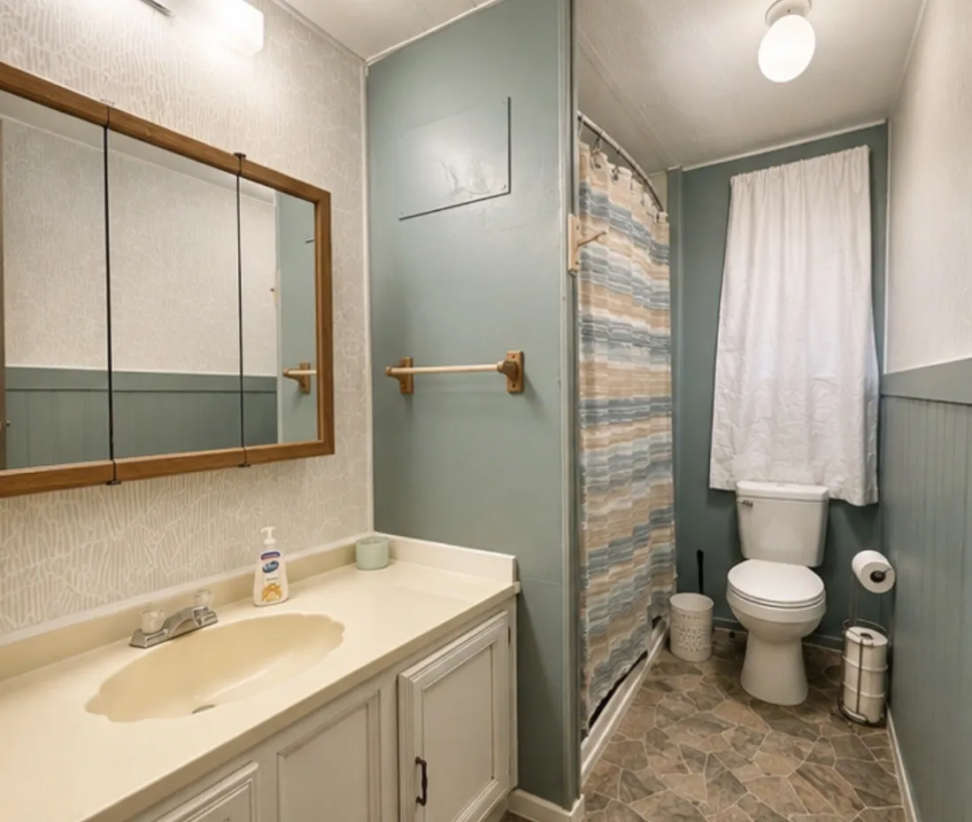 Bathroom featuring a built-in vanity with integrated sink, wood-framed medicine cabinet, and a shower with a curved rod