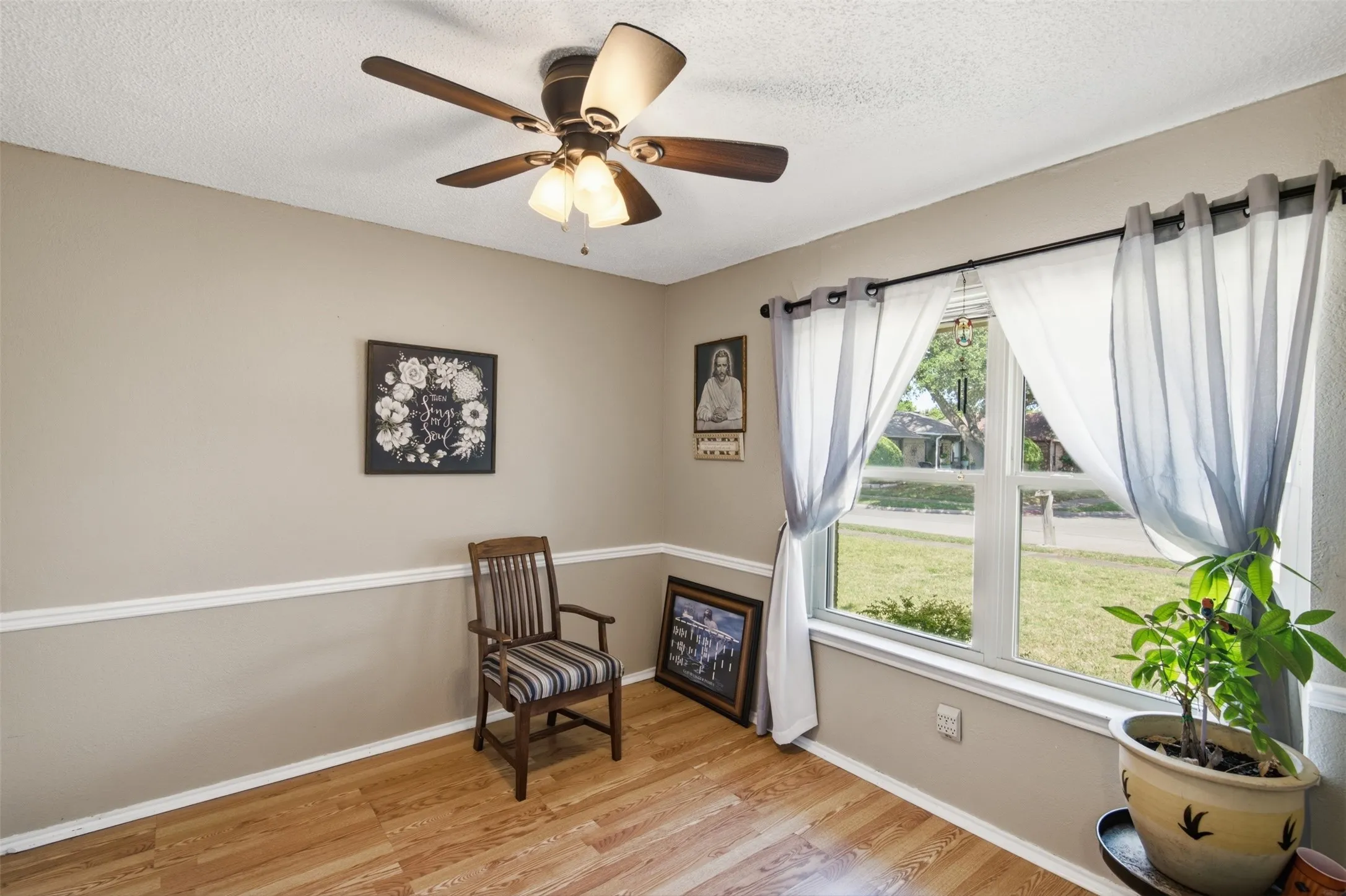 Room featuring a ceiling fan with integrated lighting, wood-finish flooring, and crown molding