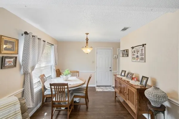 Dining area featuring wood-finish flooring, neutral wall paint, and white trim